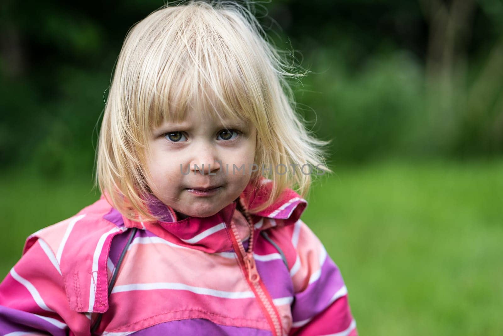 Sad or bewildered girl standing alone in the garden
