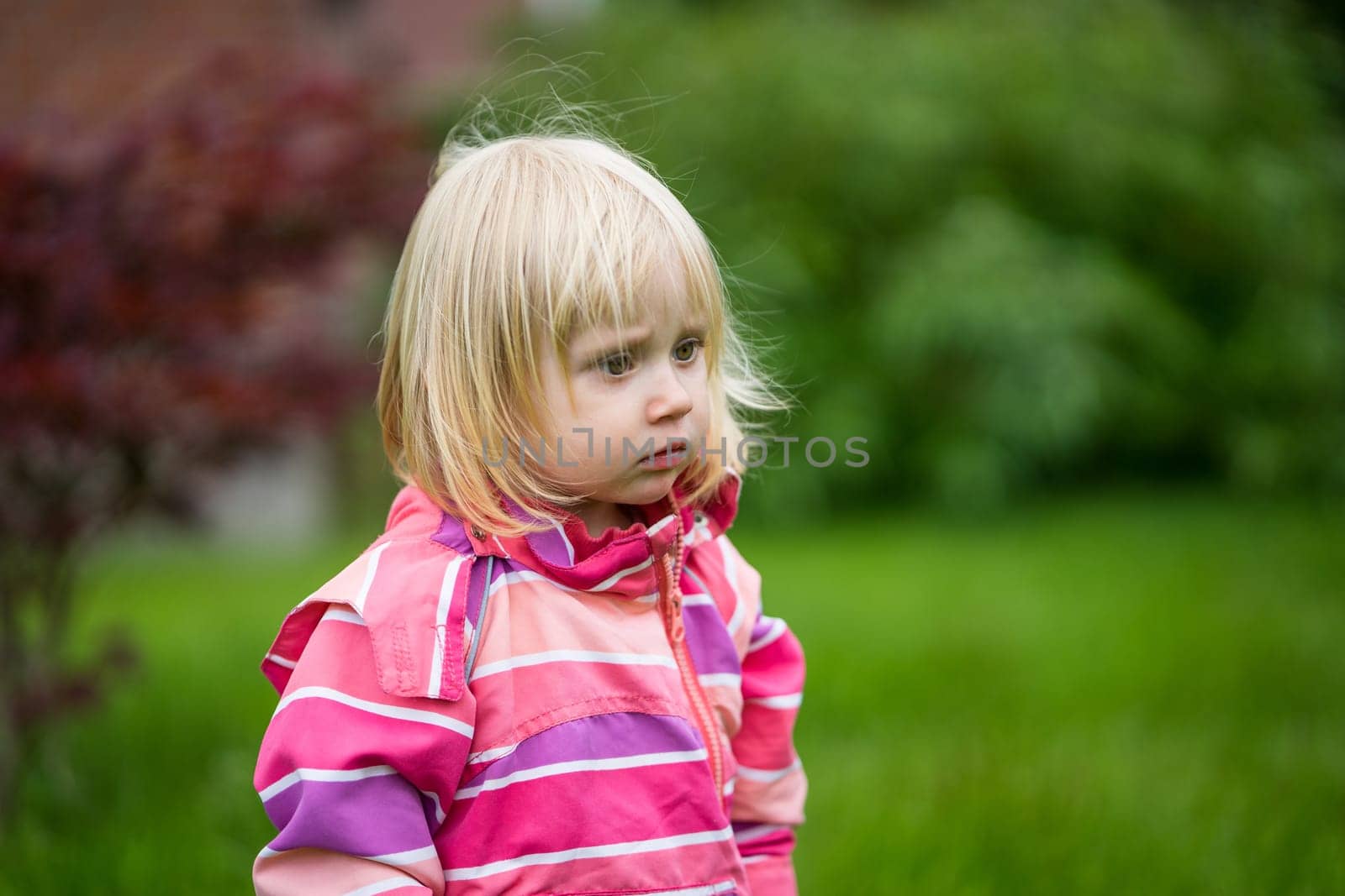 Sad or bewildered girl standing alone in the garden