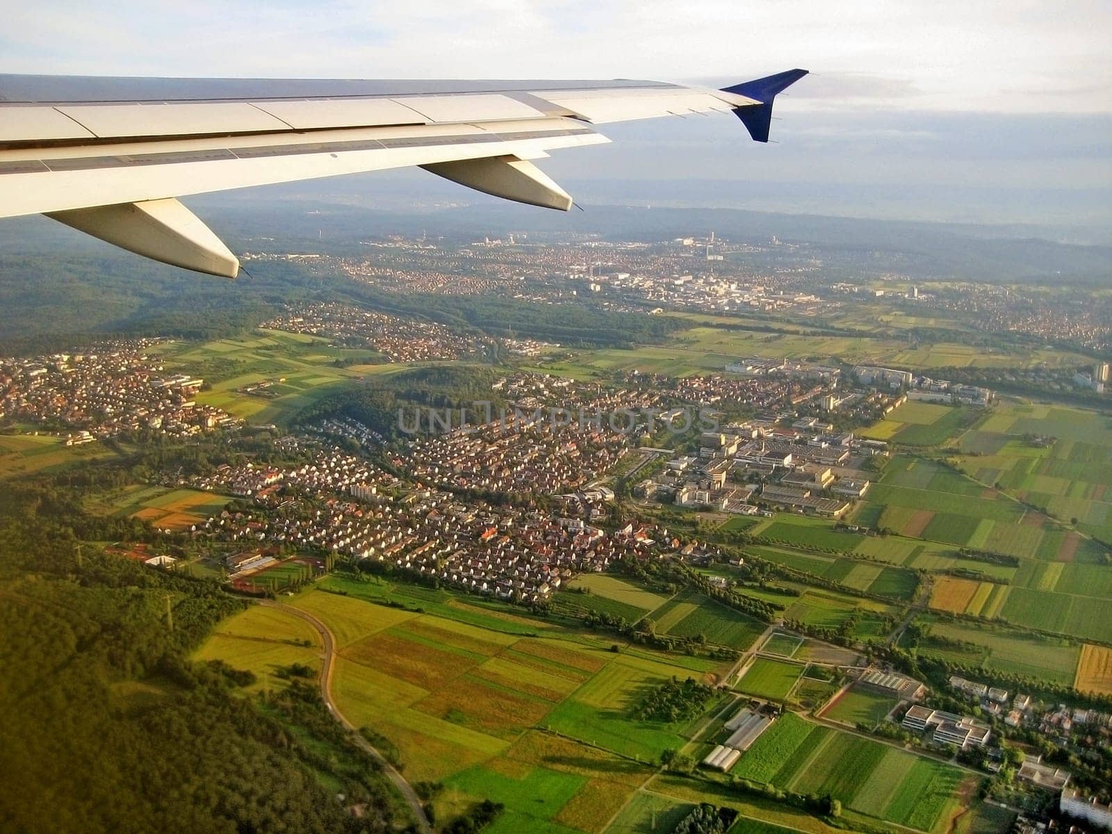 Typical german village during landing approach surrounded by fields and forest, aerial view