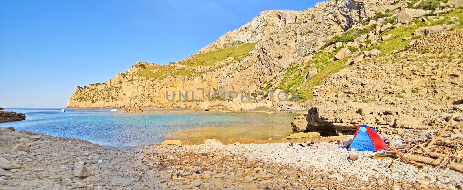Bay Cala Figuera panorama, Majorca, Spain - rocky beach with beach shelter - impressive mountain cliff in the background