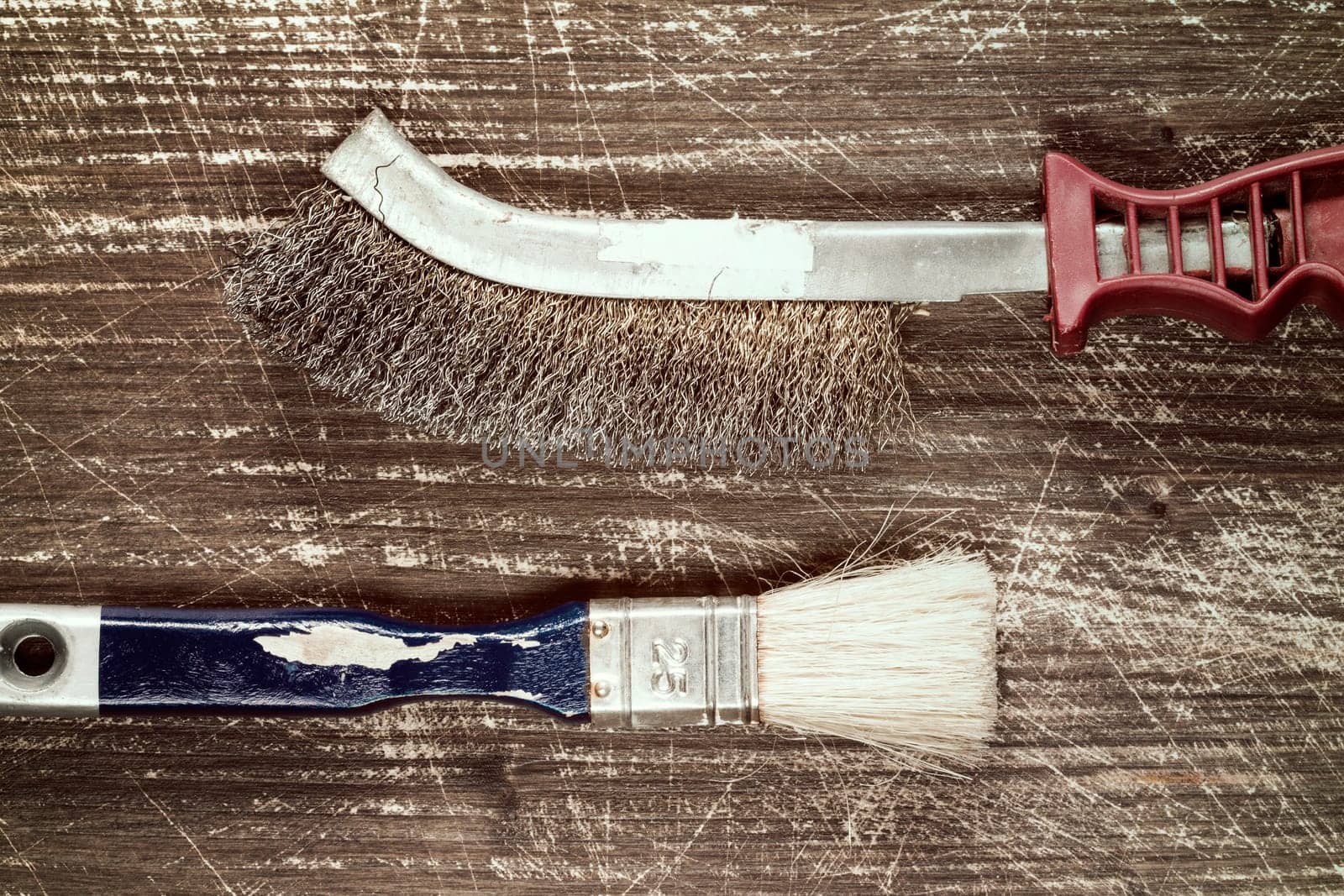 Paintbrush and wire brush on the old wooden background with copy-space