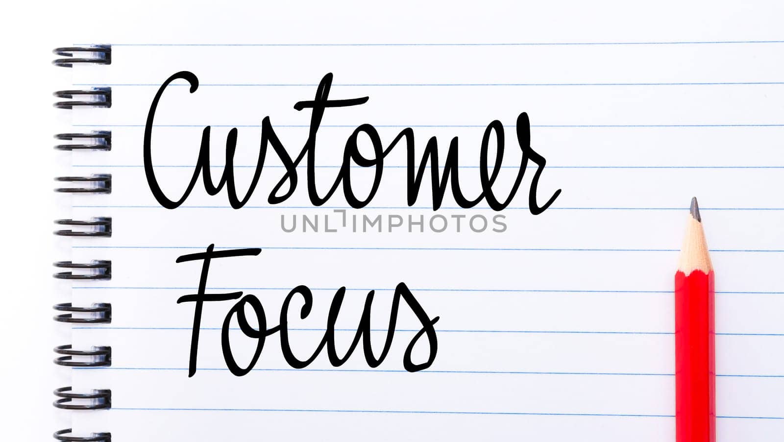 Customer Focus written on notebook page with red pencil on the right