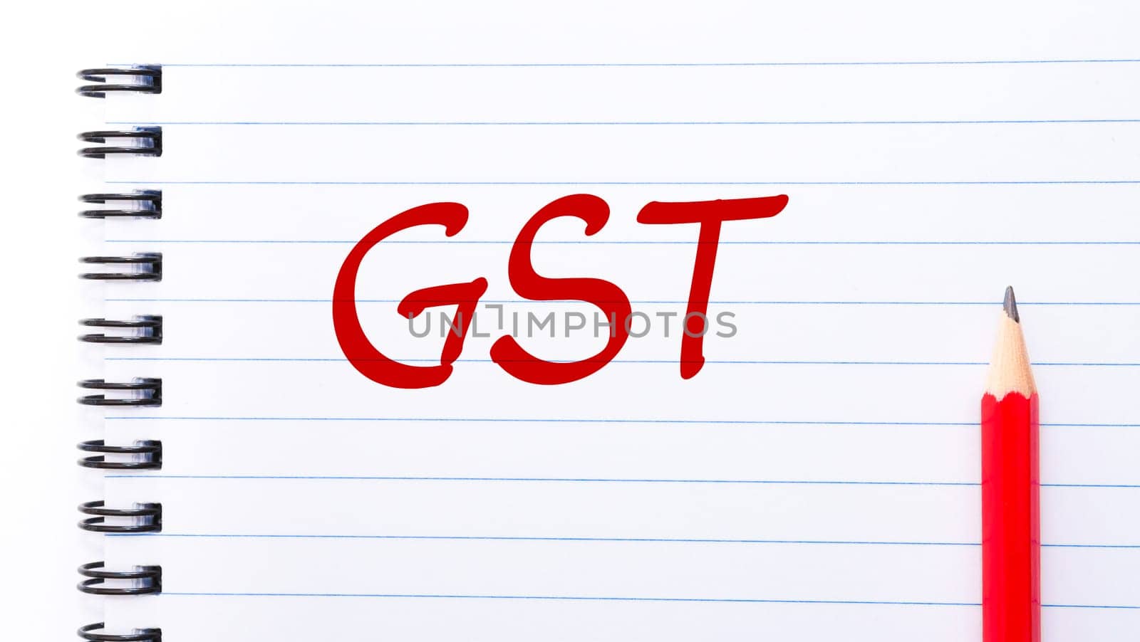 GST Goods and services tax written on notebook page with red pencil on the right