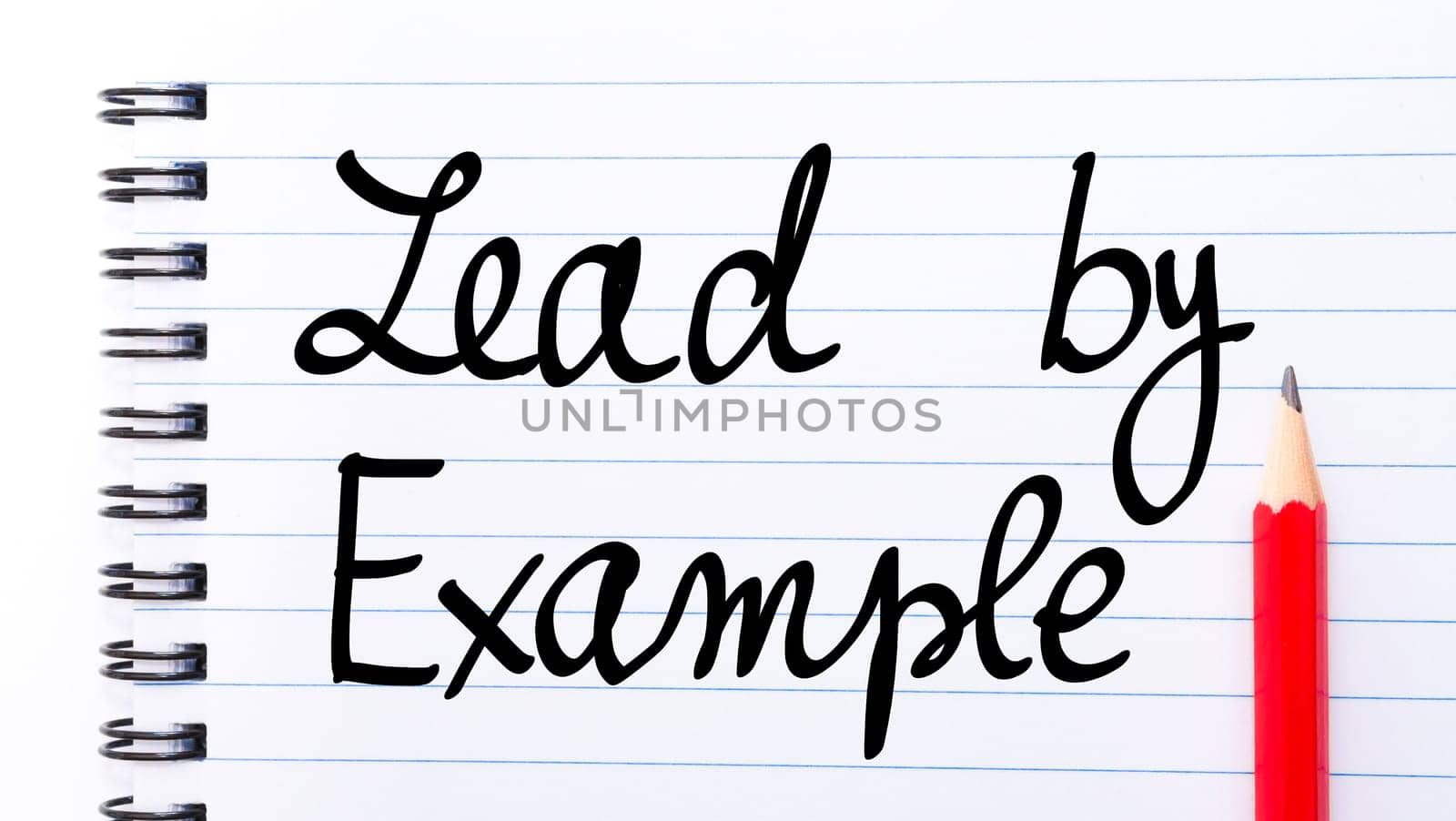 Lead By Example written on notebook page with red pencil on the right