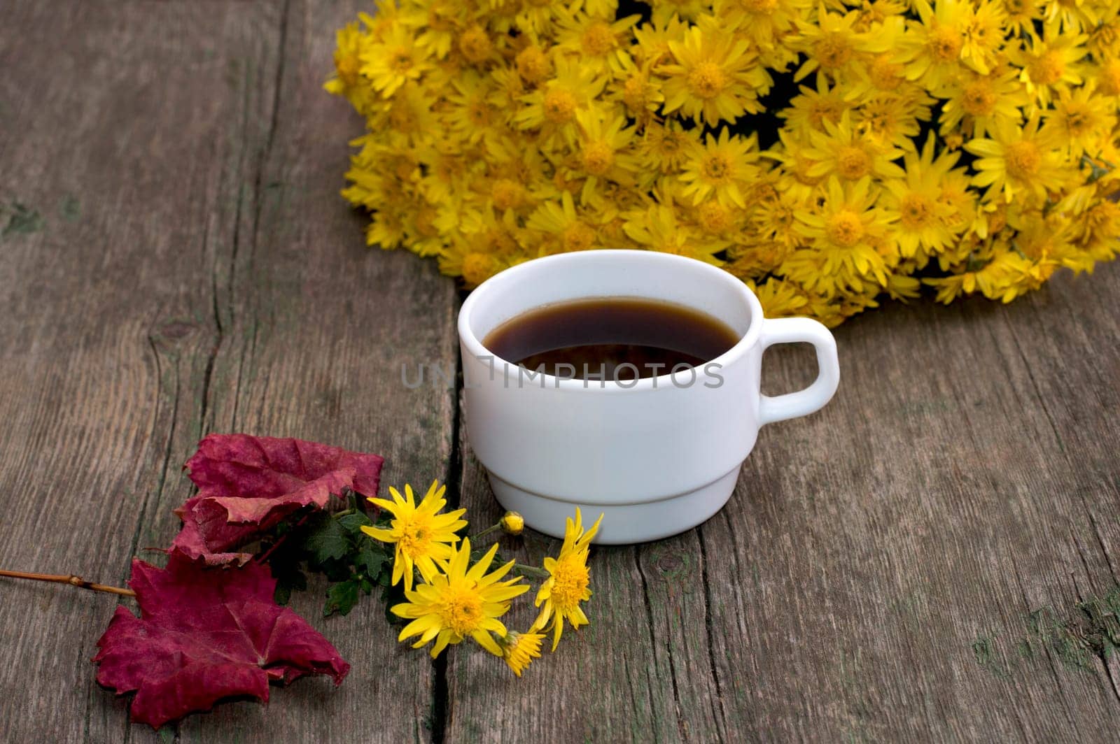 bouquet of yellow flowers, coffee, red leaf and floret, on a wooden table, fall a still life, a subject flowers and drinks