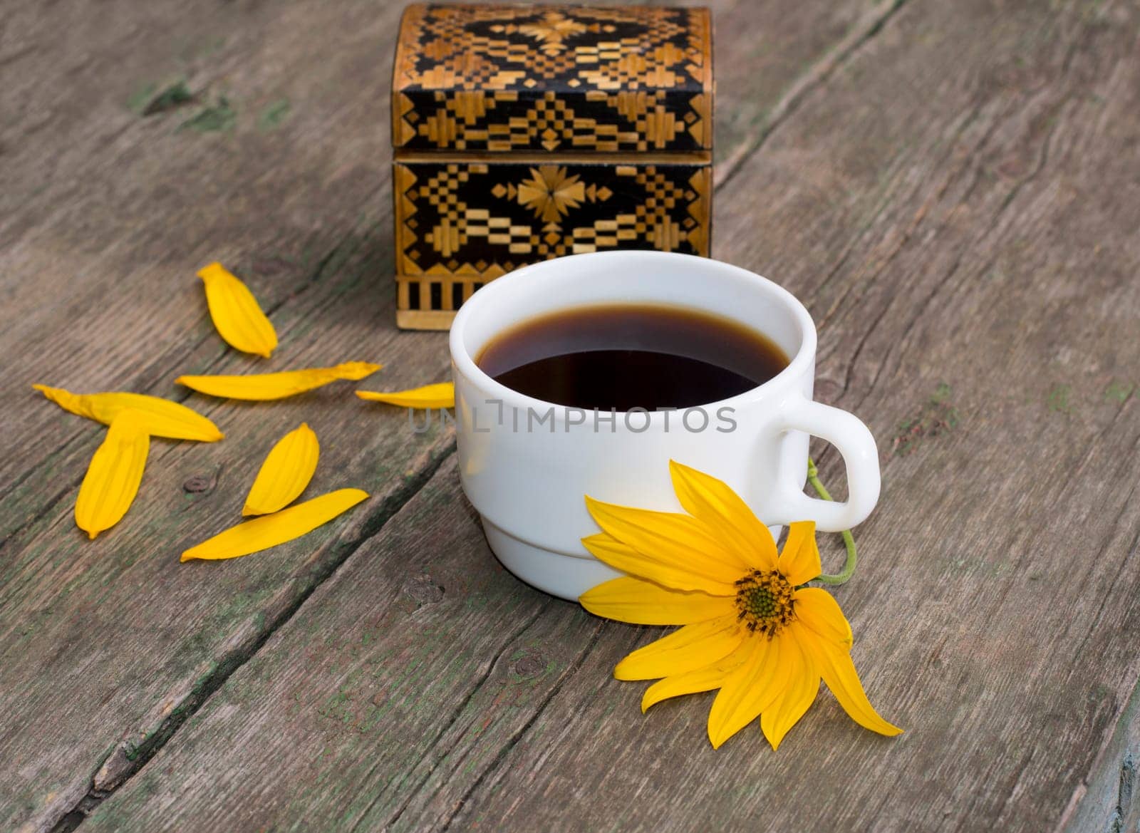 casket, petals, yellow flower and coffee, on a wooden table, a still life, a subject flowers and drinks