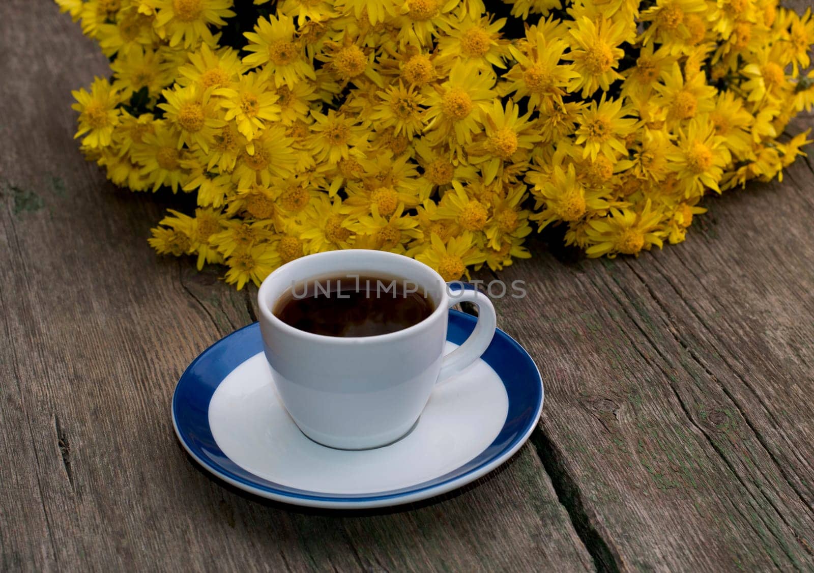 bouquet of beautiful yellow flowers and cup of black coffee, still life on a subject flowers, drinks and fall