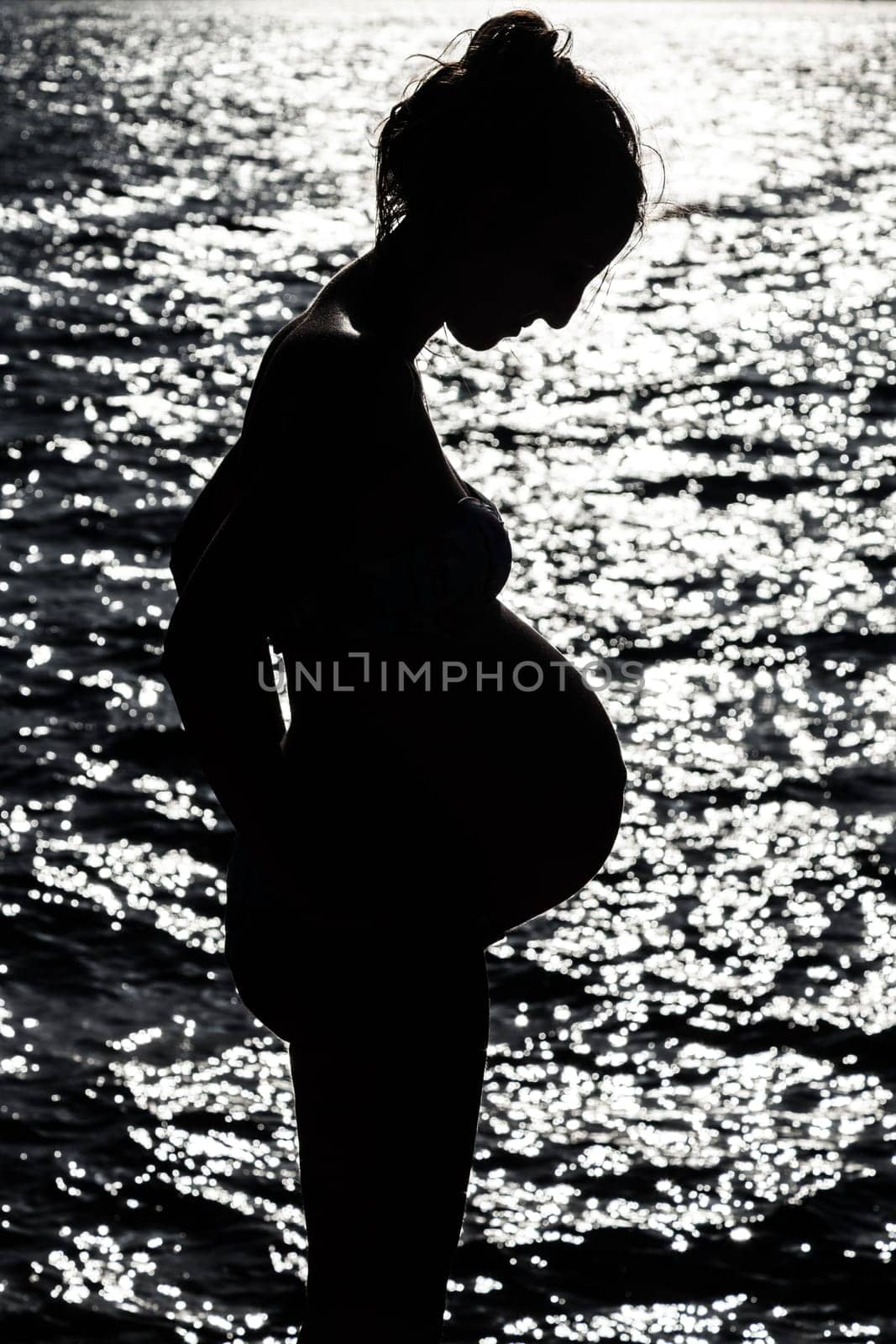 Silhouette of pregnant woman at the sunset at french riviera