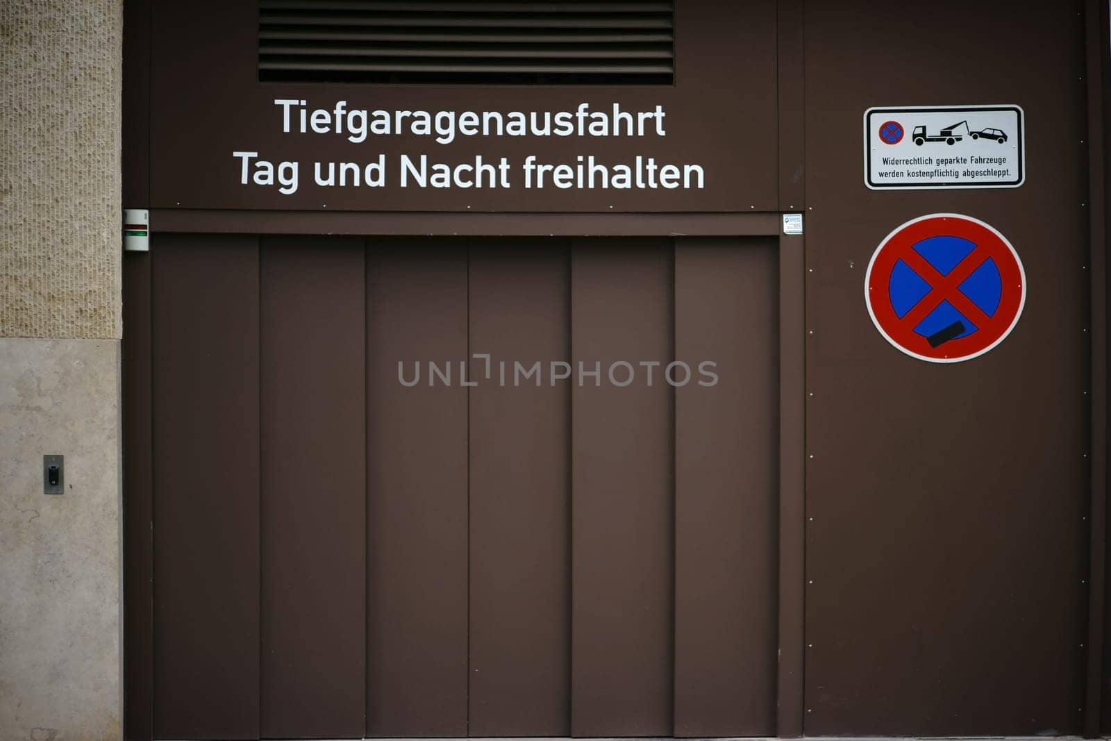 The exit of an underground car park with traffic signs and a sliding door.