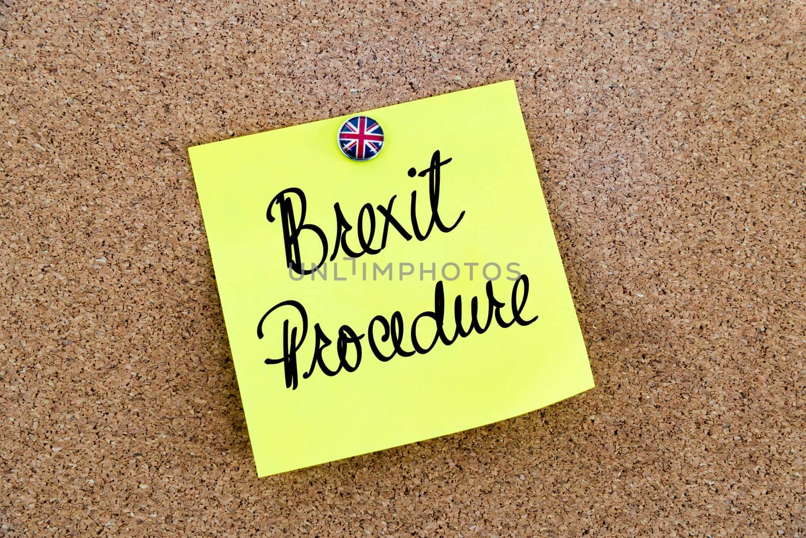 Yellow paper note pinned on cork board with Great Britain flag thumbtack, written text BREXIT PROCEDURE, United Kingdom exit from European Union