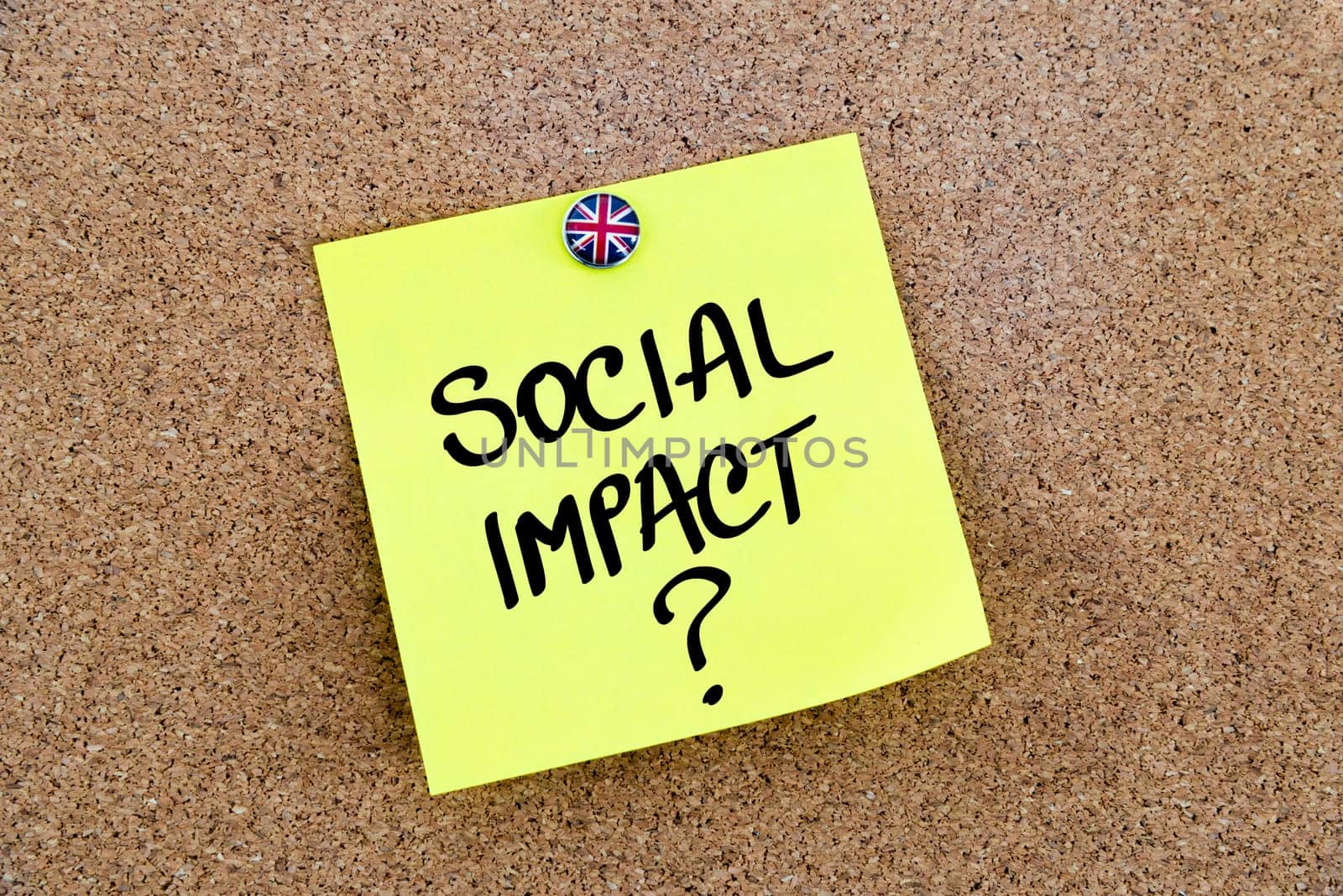 Yellow paper note pinned on cork board with Great Britain flag thumbtack, written text SOCIAL IMPACT ?, United Kingdom exit from European Union concept
