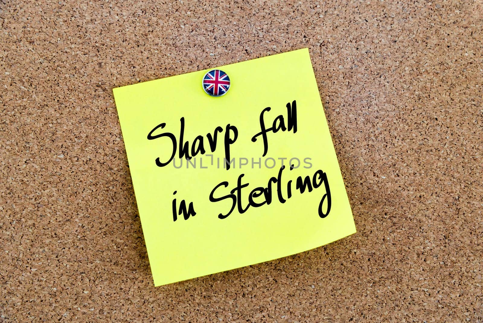 Yellow paper note pinned on cork board with Great Britain flag thumbtack, written text SHARP FALL IN STERLING, United Kingdom exit from European Union