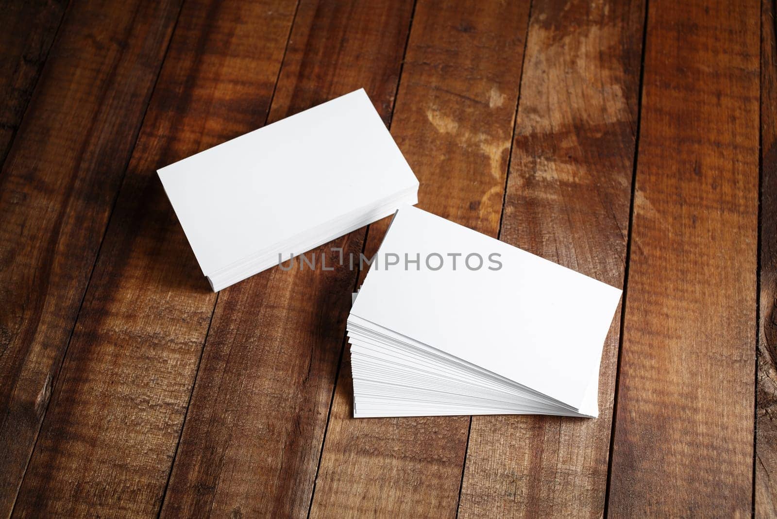 Photo of blank business cards on vintage wooden table background. Mock up for design portfolios. Responsive design template. Top view.