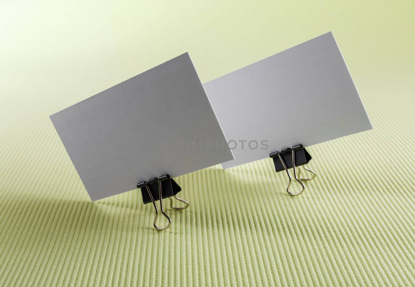 Photo of two blank business cards on a green background.