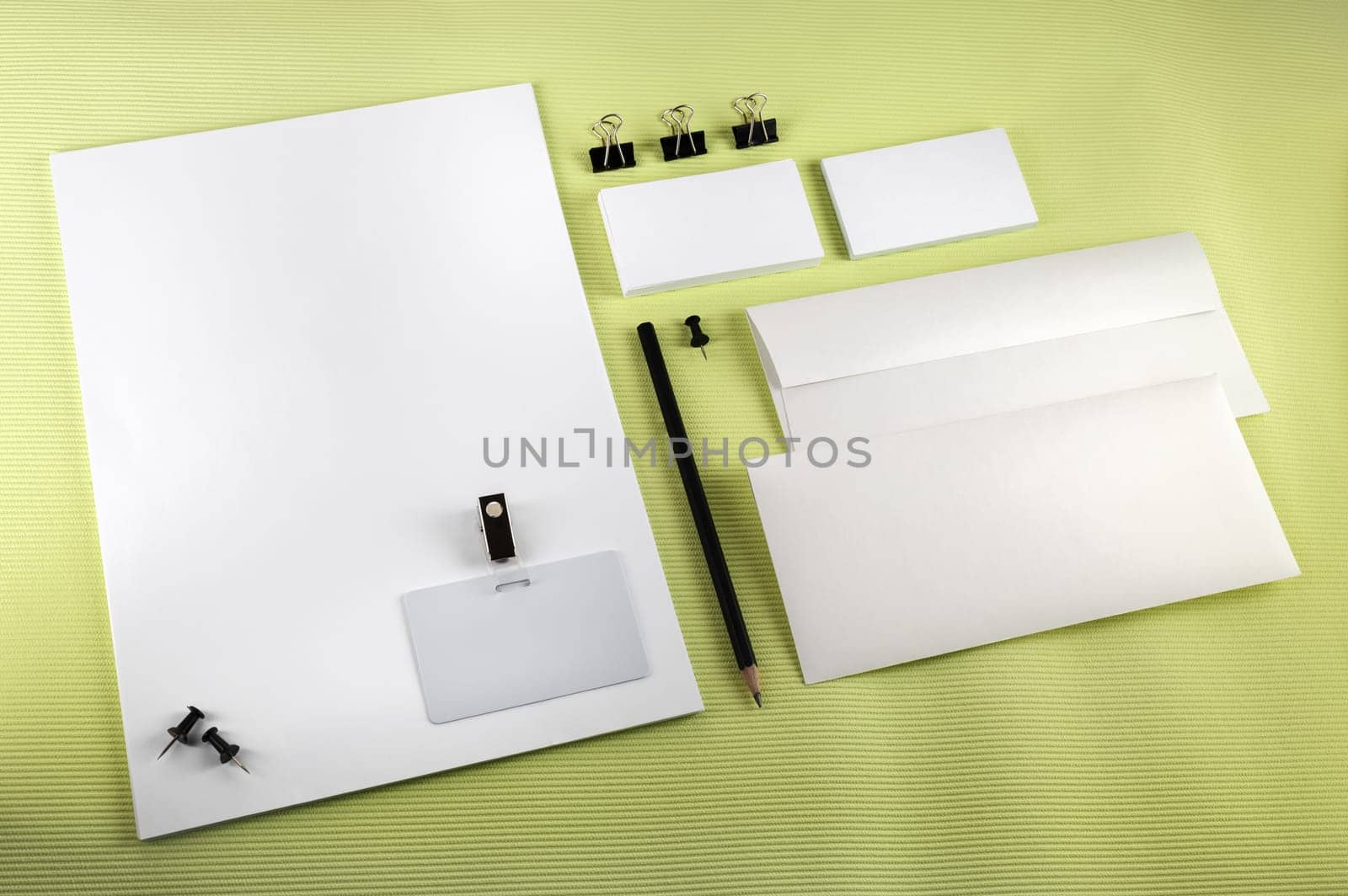 Blank corporate identity set on green background. Top view.