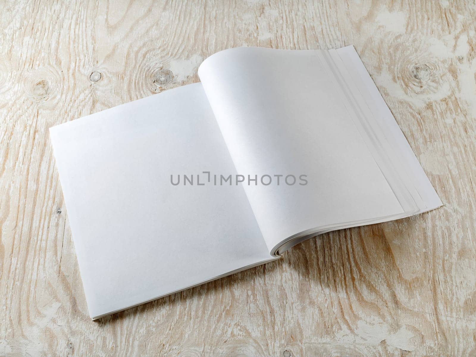 Blank booklet on wooden textural background with soft shadows. Mock-up for graphic designers portfolios.