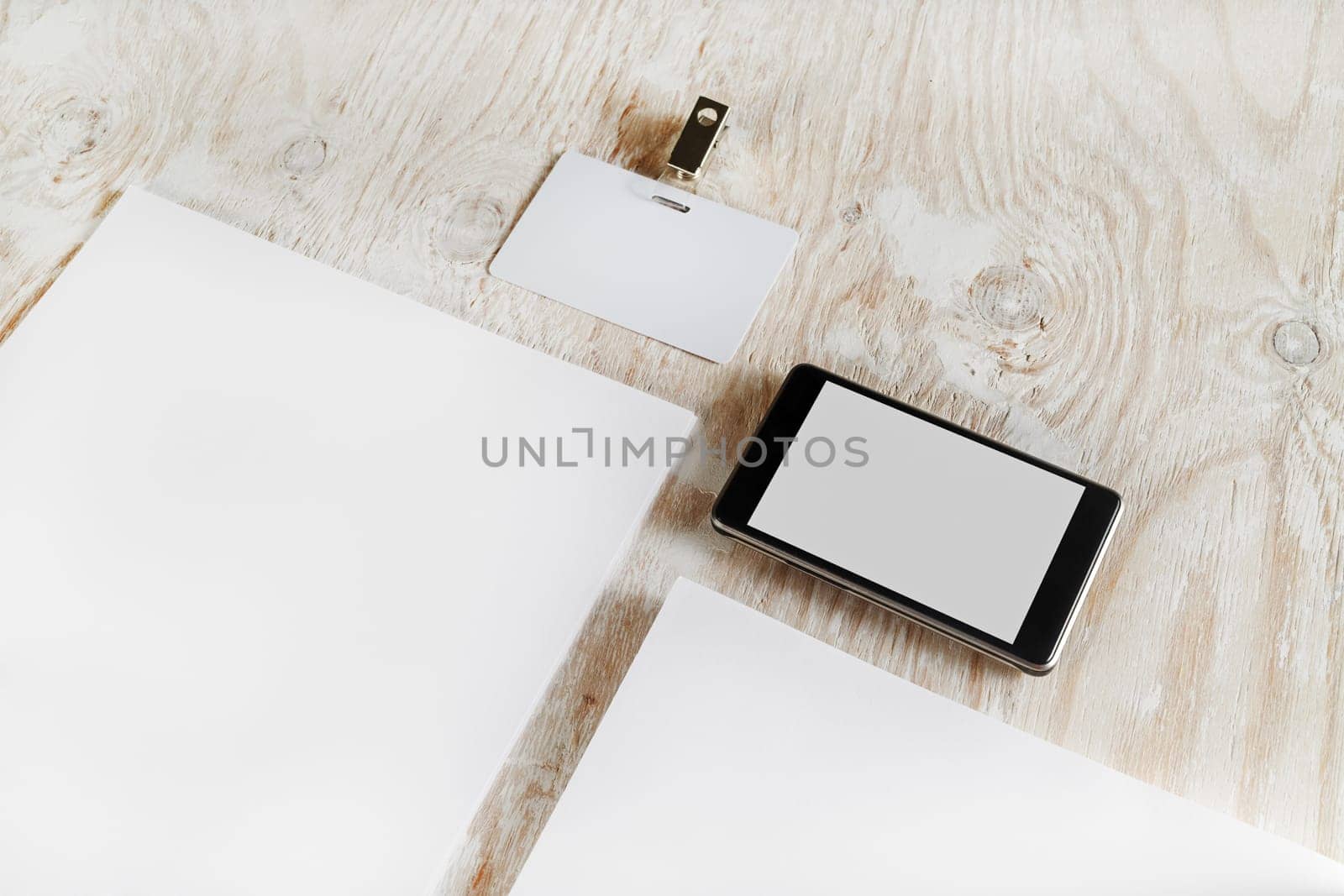 Fragment of blank stationery set. ID template on light wooden background. For design presentations and portfolios.