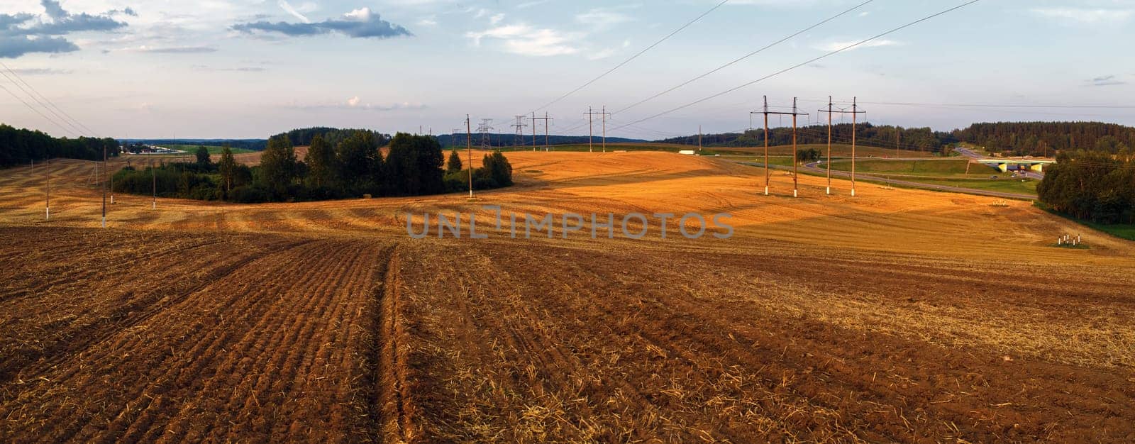 Rural landscape at sunset. Plowed field after harvest.