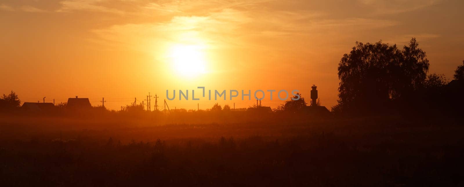 Orange sunset in the countryside. Russian village.