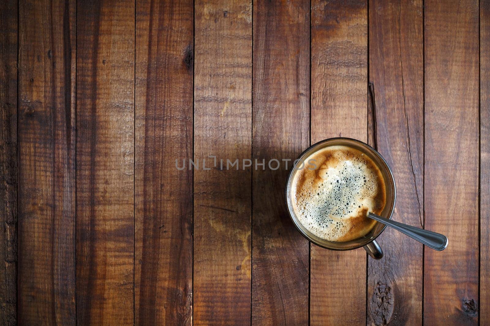 A cup of coffee on the background of the wooden table. Coffee on wooden background. Space for text. Top view.