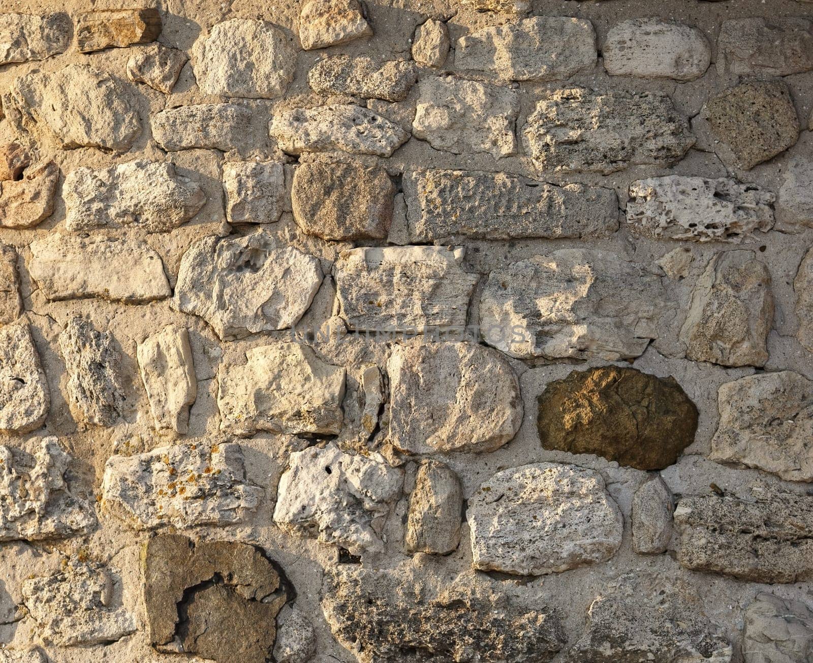 Old vintage stone wall of large rough stones.