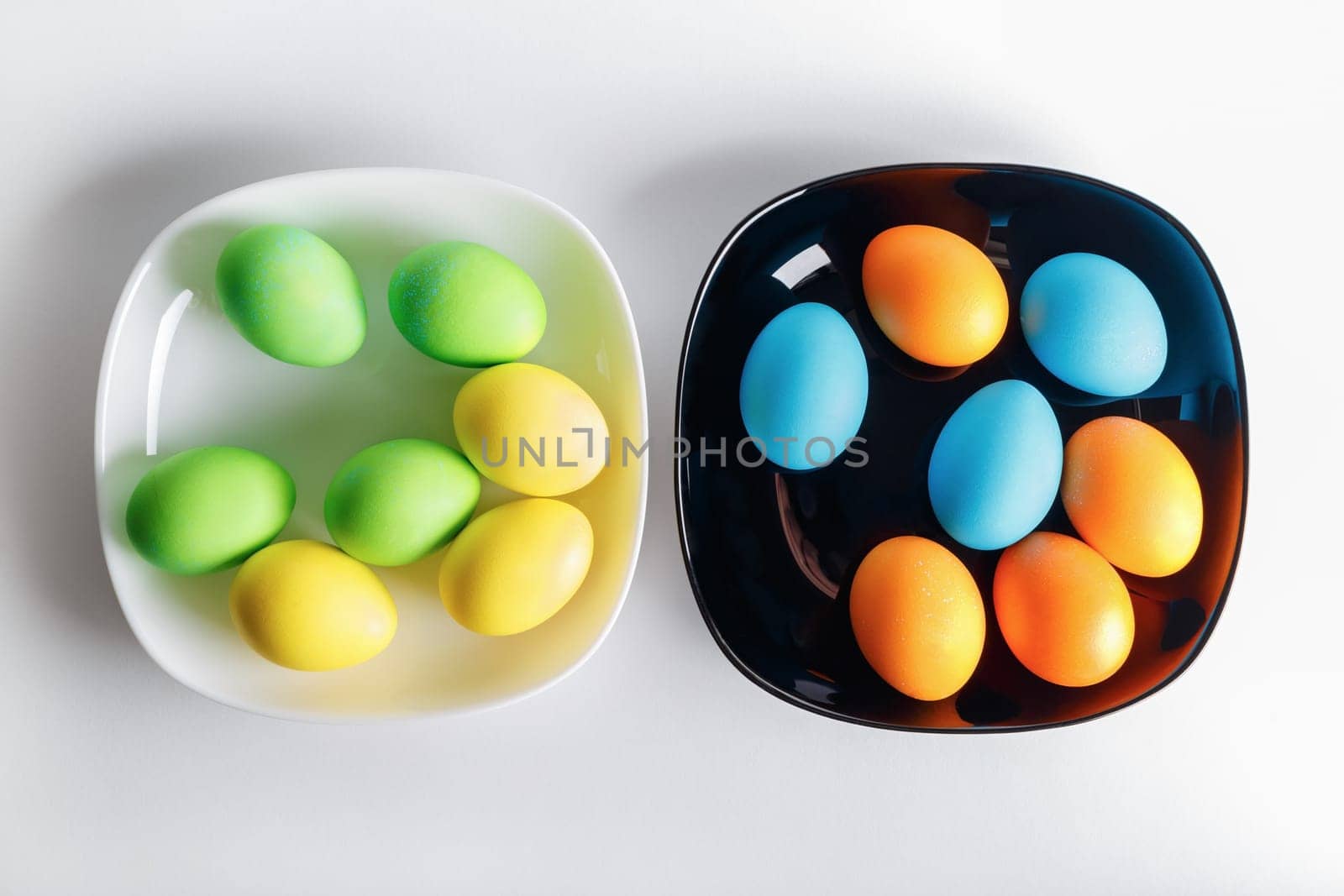 Easter eggs on a black and white plates. Top view.