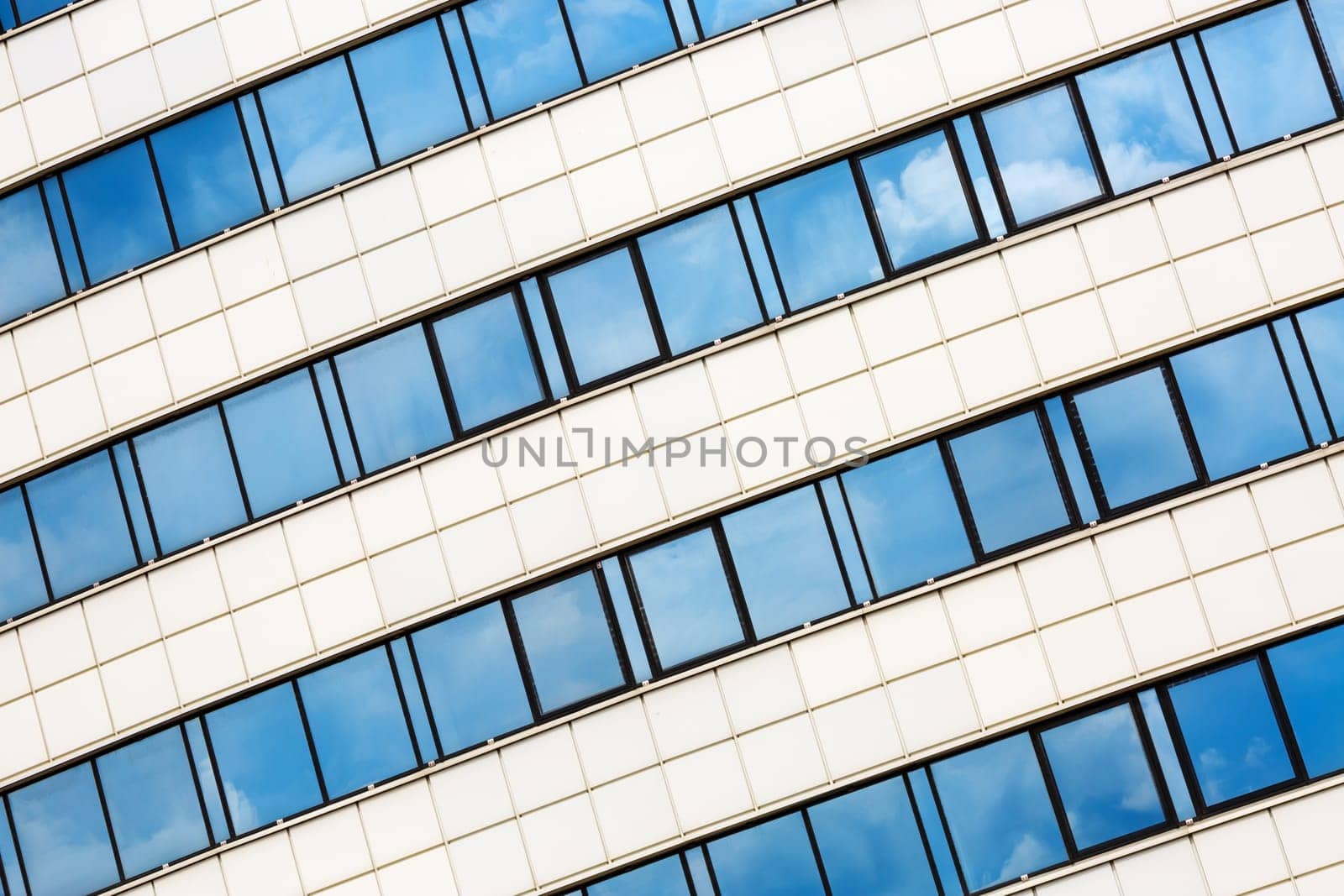 MINSK, BELARUS - MAY 03, 2016: Close-up of Minsk-Arena - a sports and entertainment complex in the city of Minsk, Belarus. Close-up of modern architecture. Reflection of blue sky with clouds in the windows.
