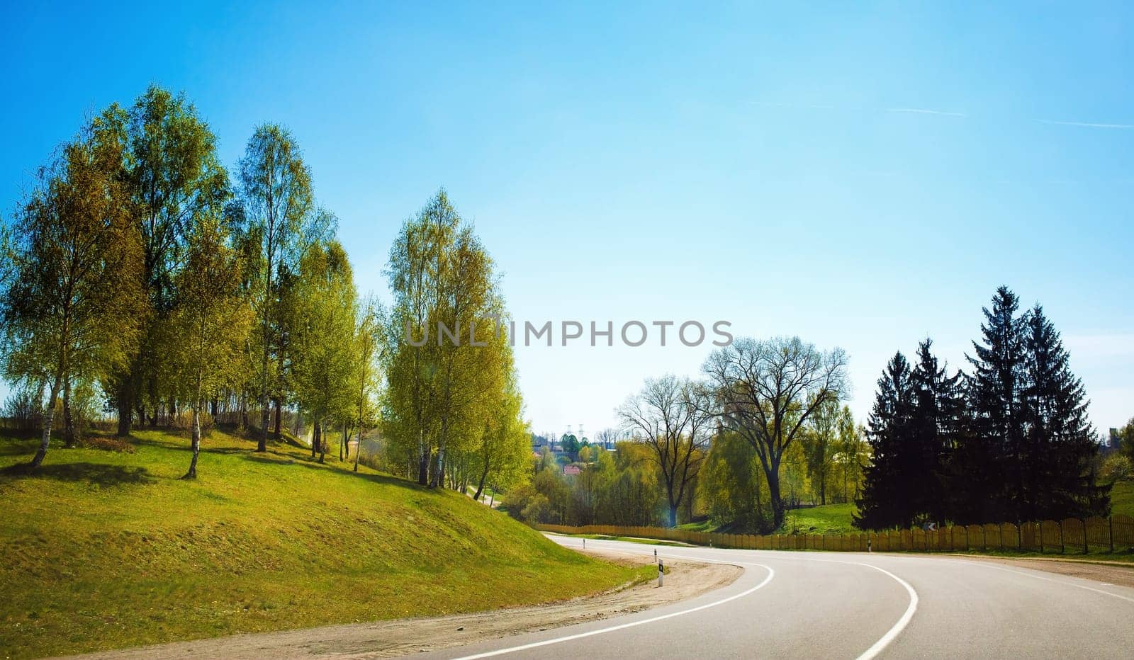 Asphalt road in the countryside. Sunny summer day. Turn of asphalt road.