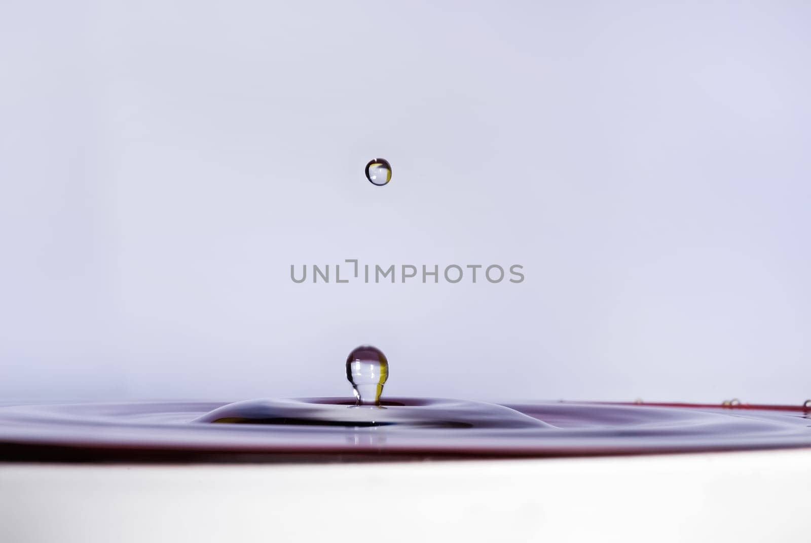 A drop of water falling into the water. Shallow depth of field. Selective focus.