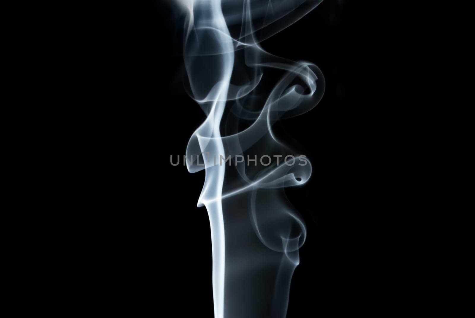 Photo of abstract light smoke swirls on black background. Studio shot.