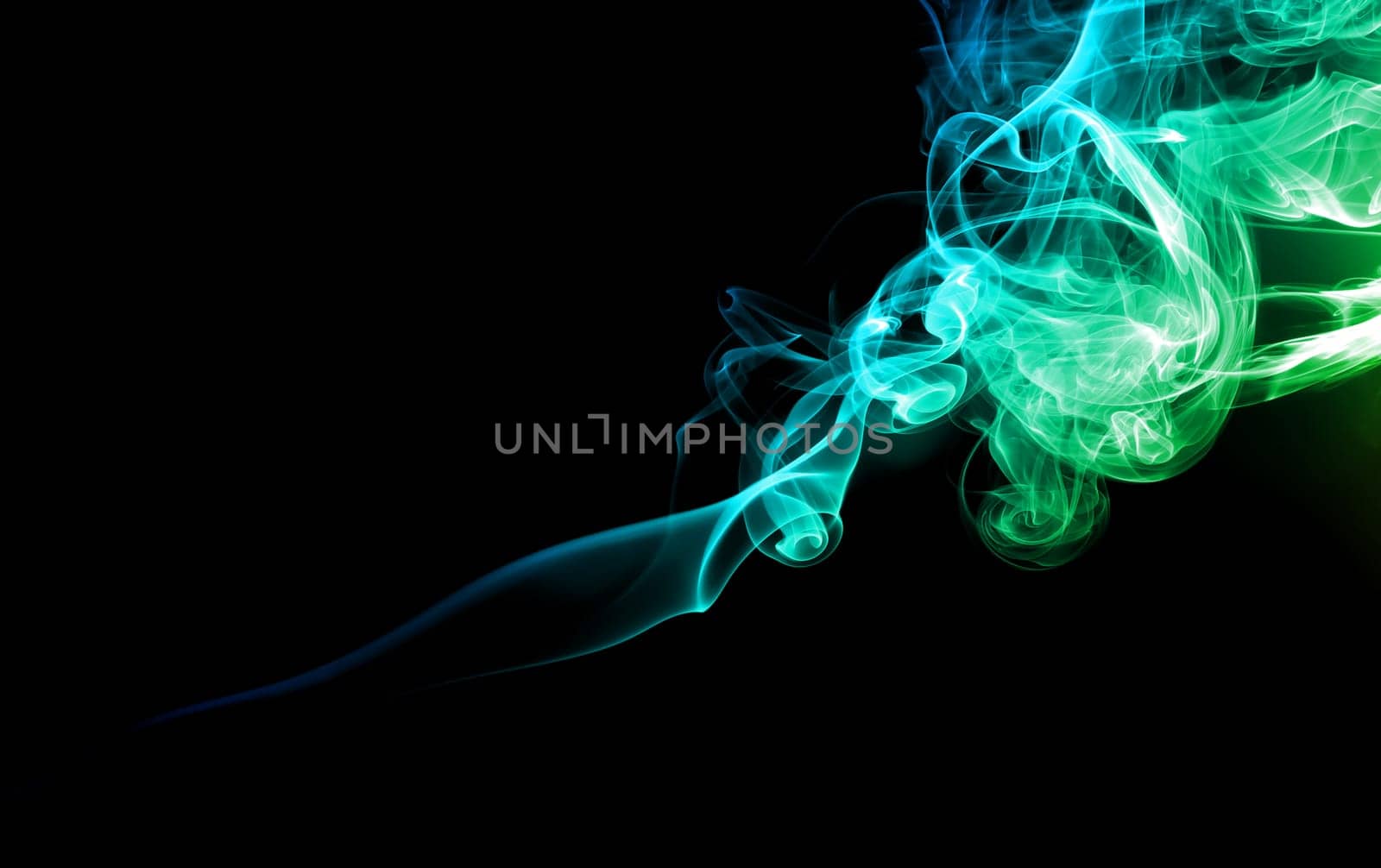 Abstract bright colored green and blue smoke on a dark background.