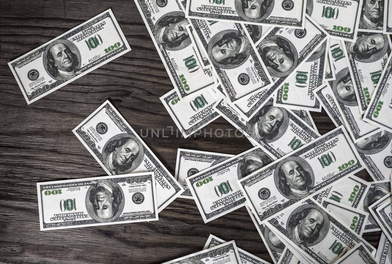 Many one hundred dollar bills on dark wooden background. Fake money. Concept of business theme.
