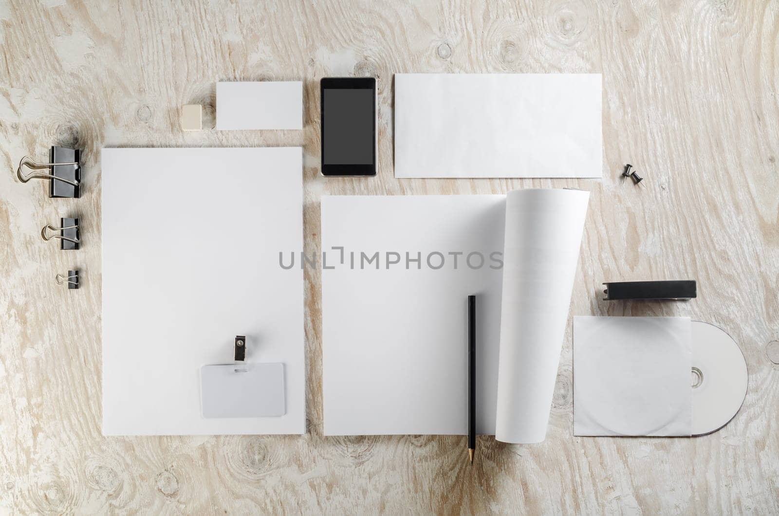 Photo of blank stationery set on light wooden background. Template for design presentations and portfolios.