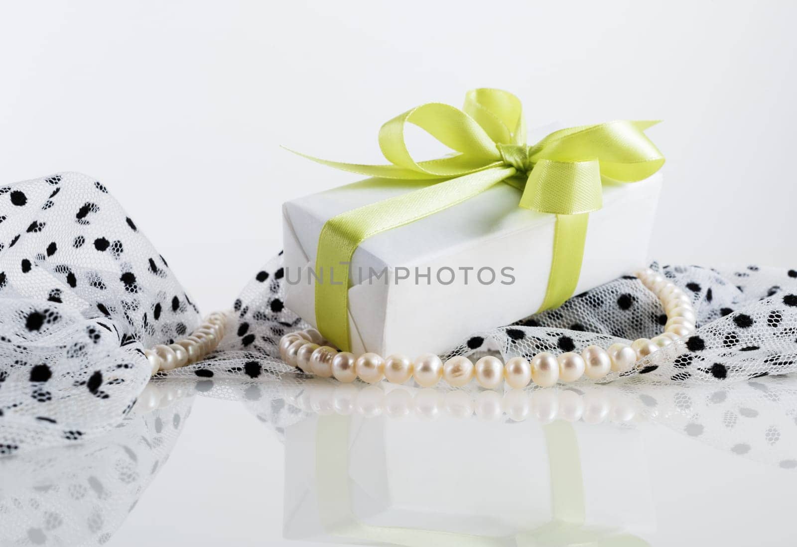 Still life with gift box, pearl beads and fabrics.