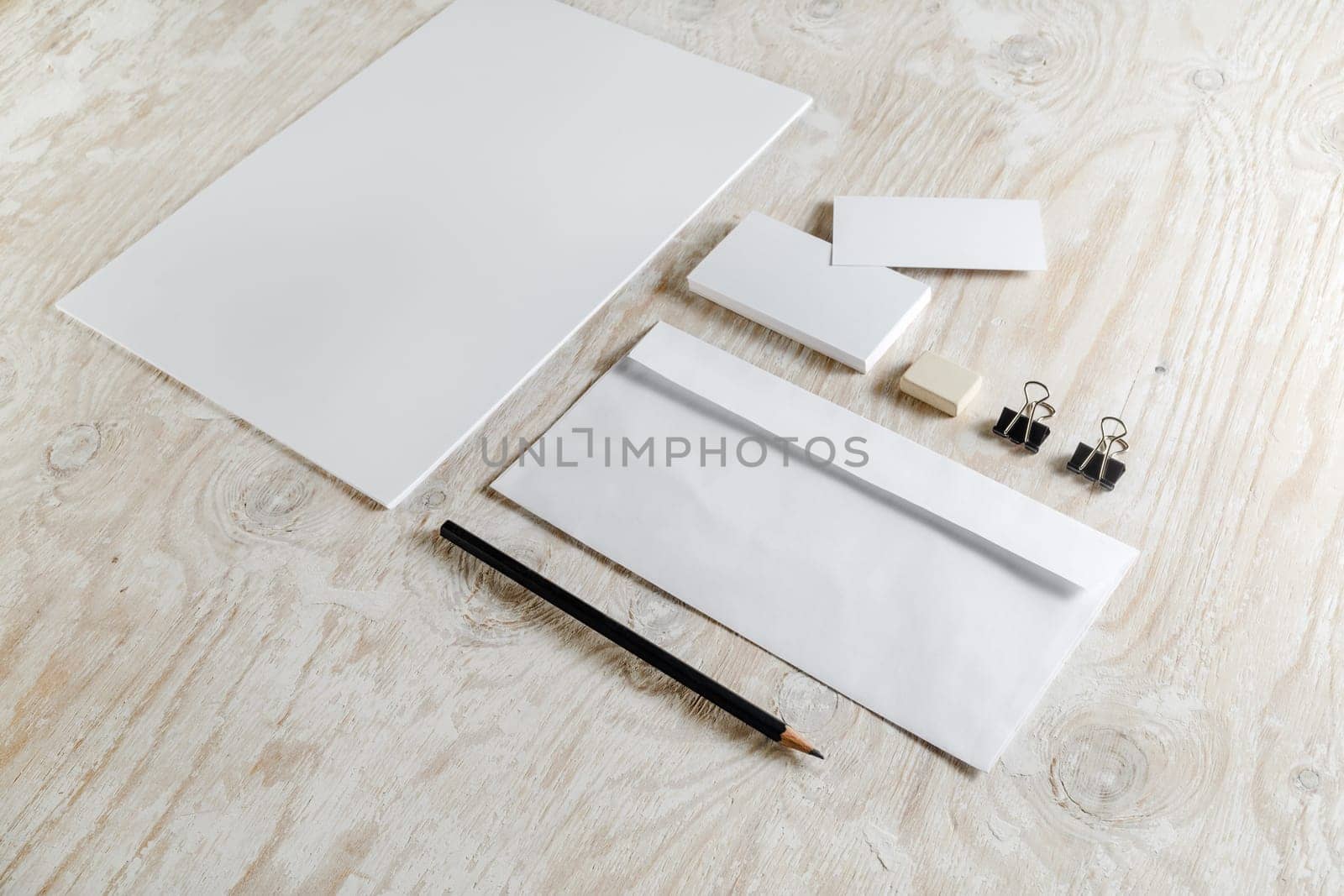 Stationery set on light wooden background. Blank template for design presentations and portfolios.