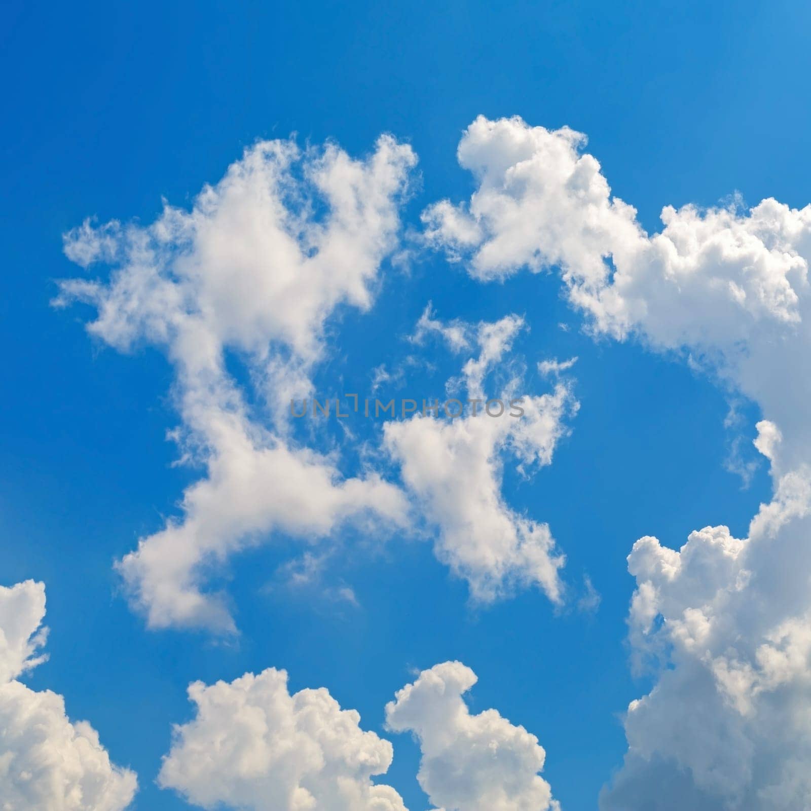 Cumulus clouds against a bright blue sky.