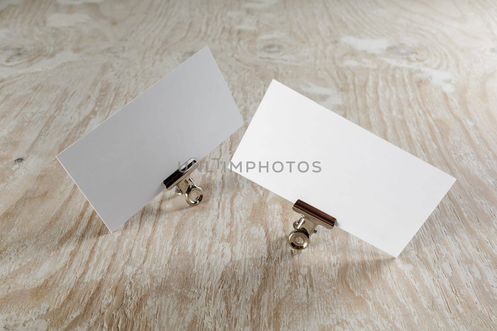 Photo of blank business cards with soft shadow on light wooden background. Mock-up for branding identity.