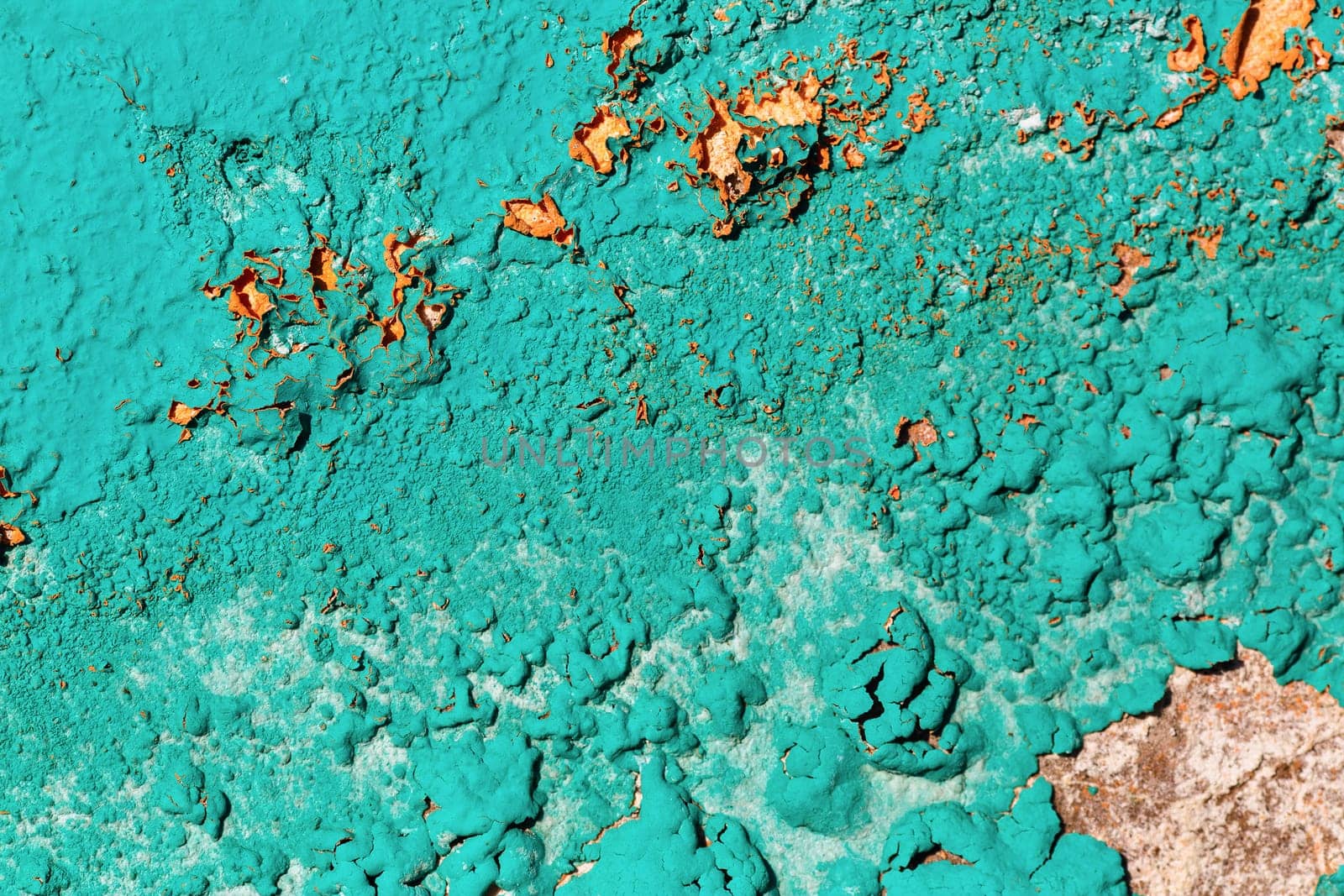 A fragment of the old wall, painted bright turquoise paint, cracked over time. Peeling paint texture.
