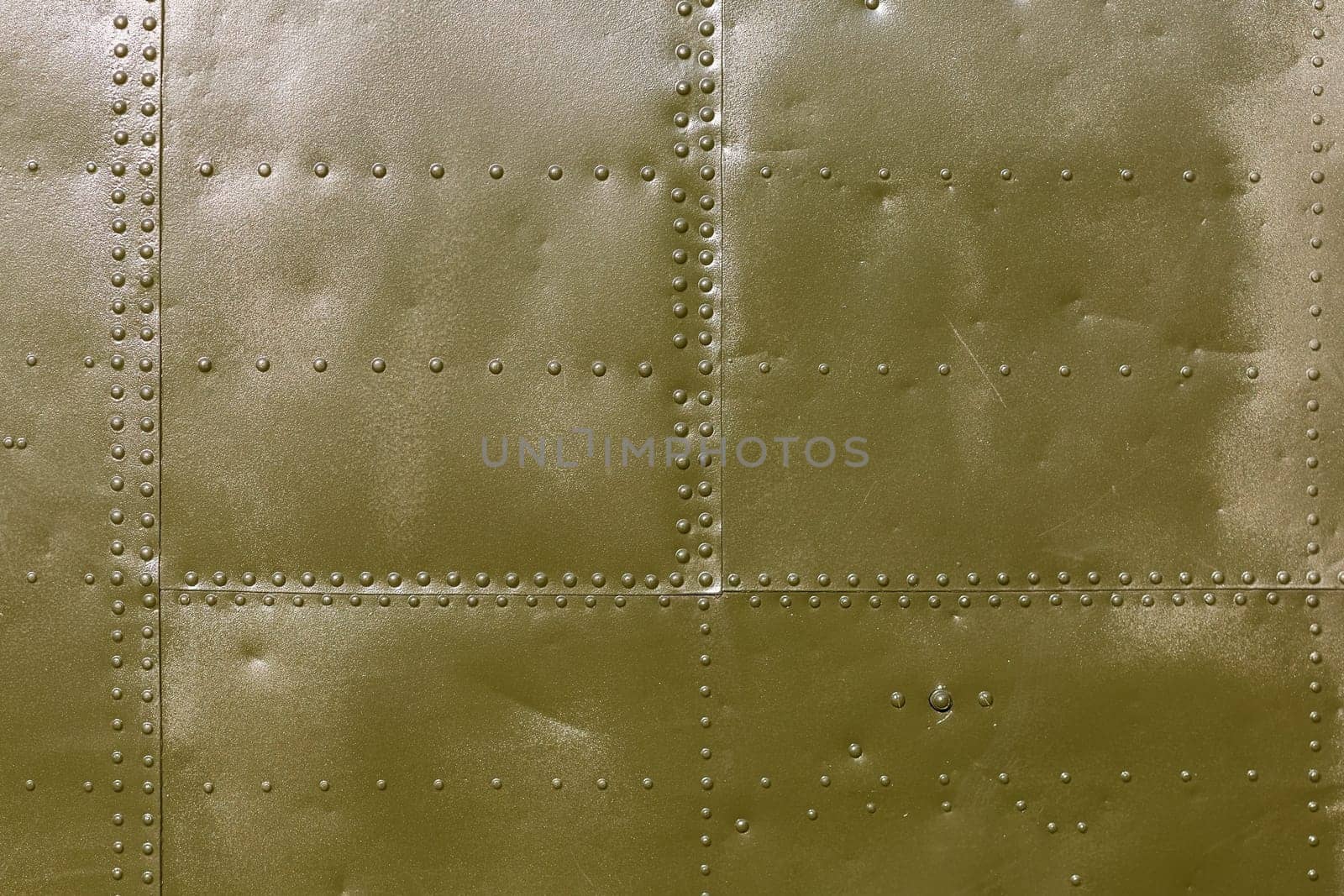 Abstract military green metal plates background texture with seams and rivets.