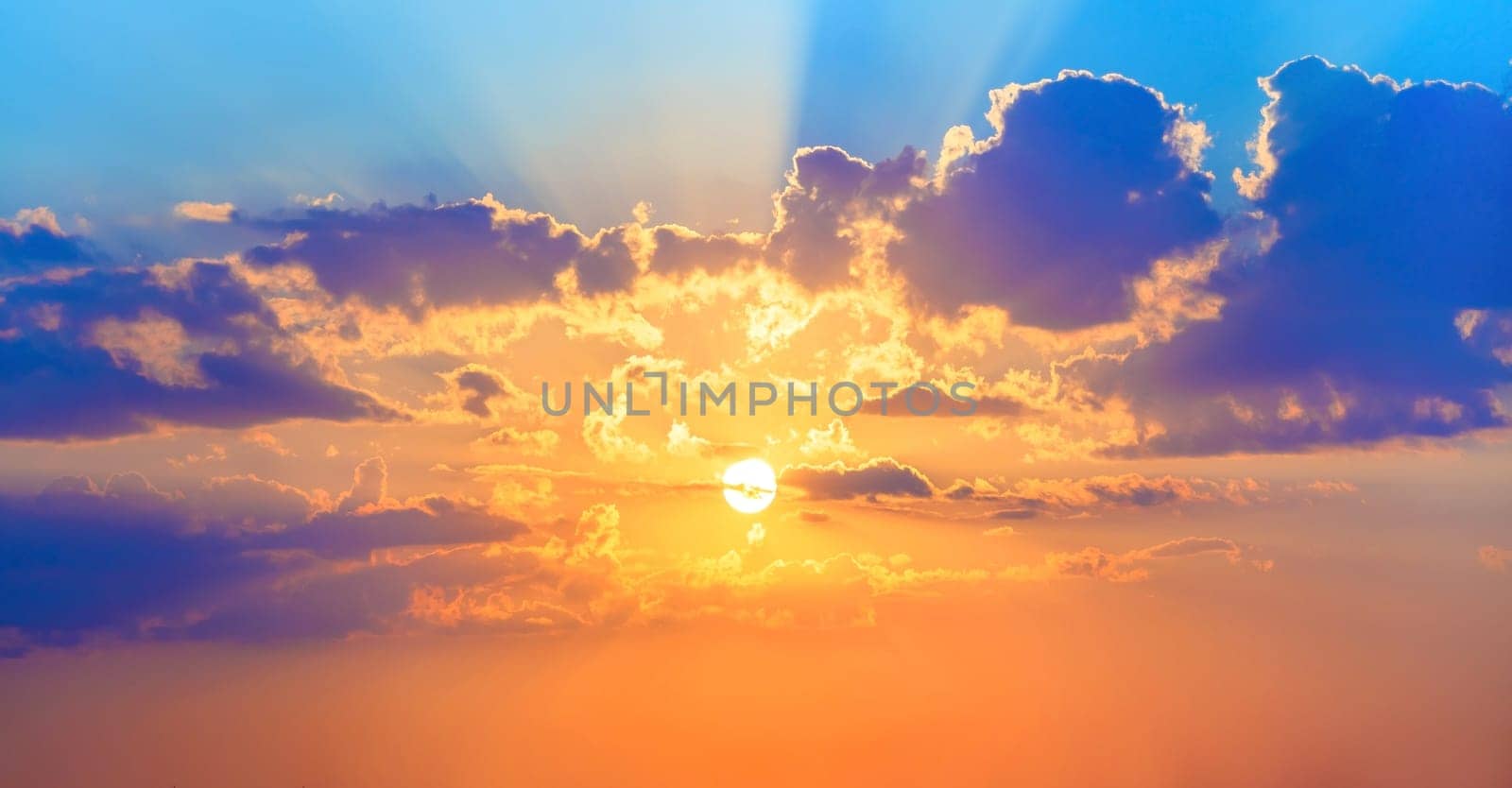 Beautiful sunset. Colorful sky with bright sun and cumulus clouds.