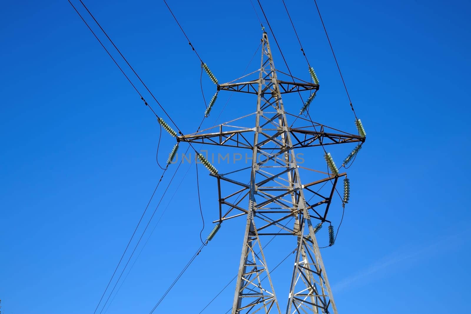 Electricity pylon on blue sky background. High voltage tower.