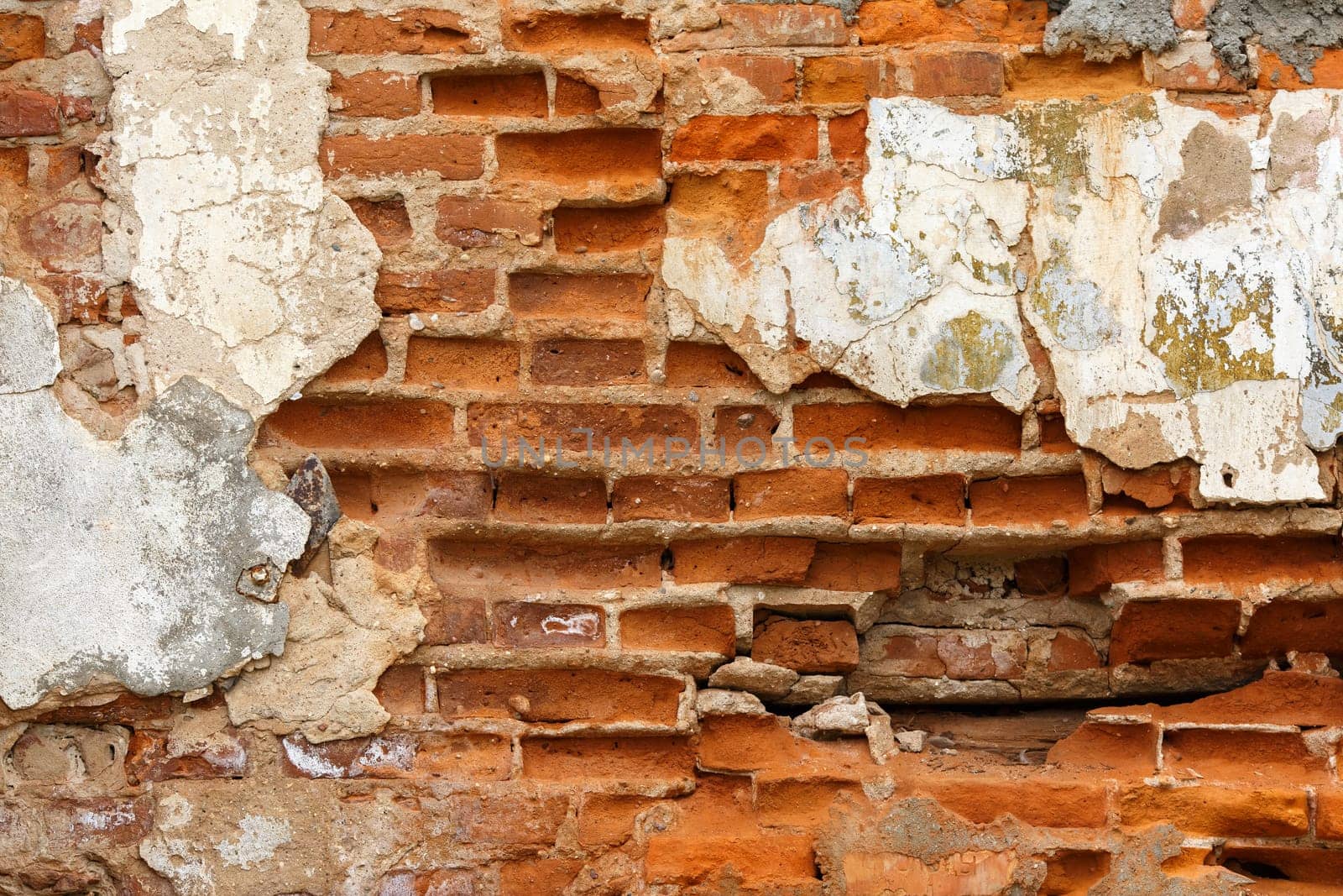 Texture of old brick with chipped plaster