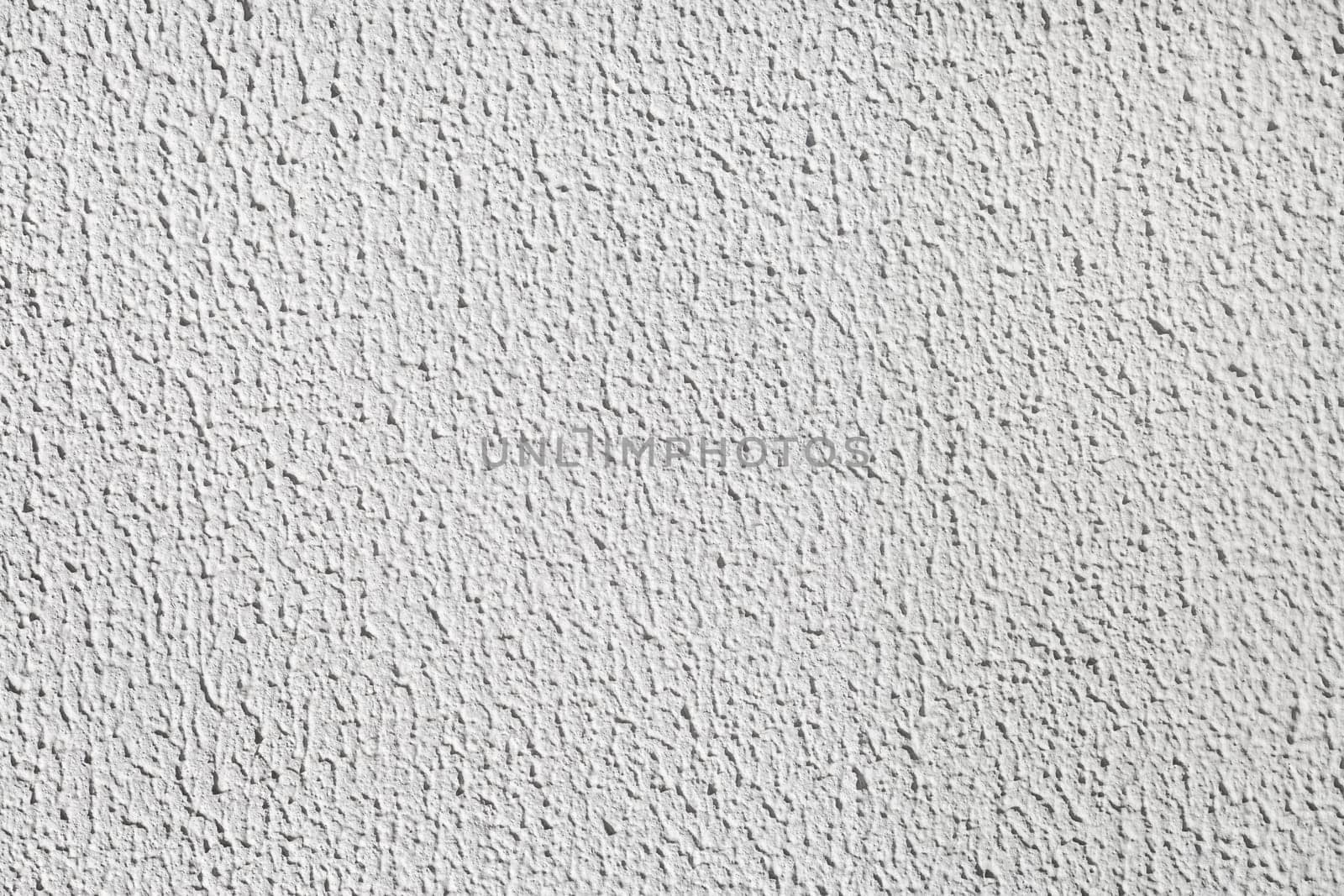Detail of stucco cement wall painted in a light gray color. Abstract plaster texture background