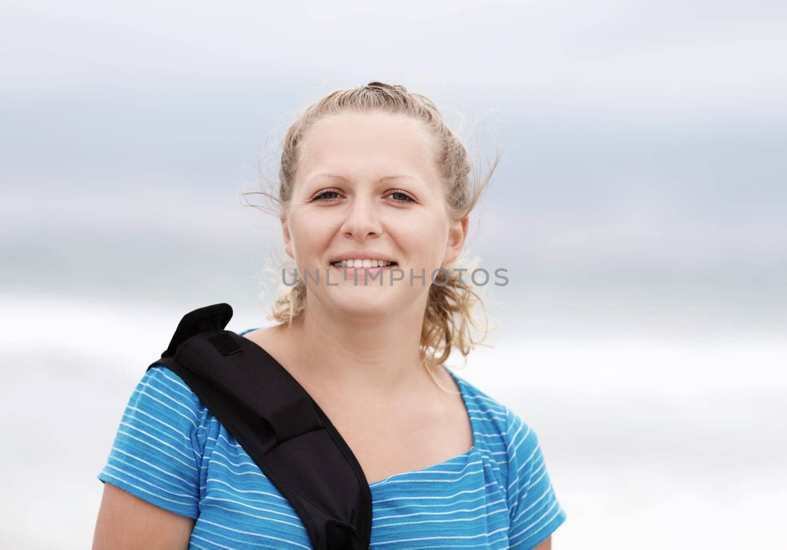 Photo of a smiling young blonde woman outdoor. Close-up of smiling girl. Selective focus on model.