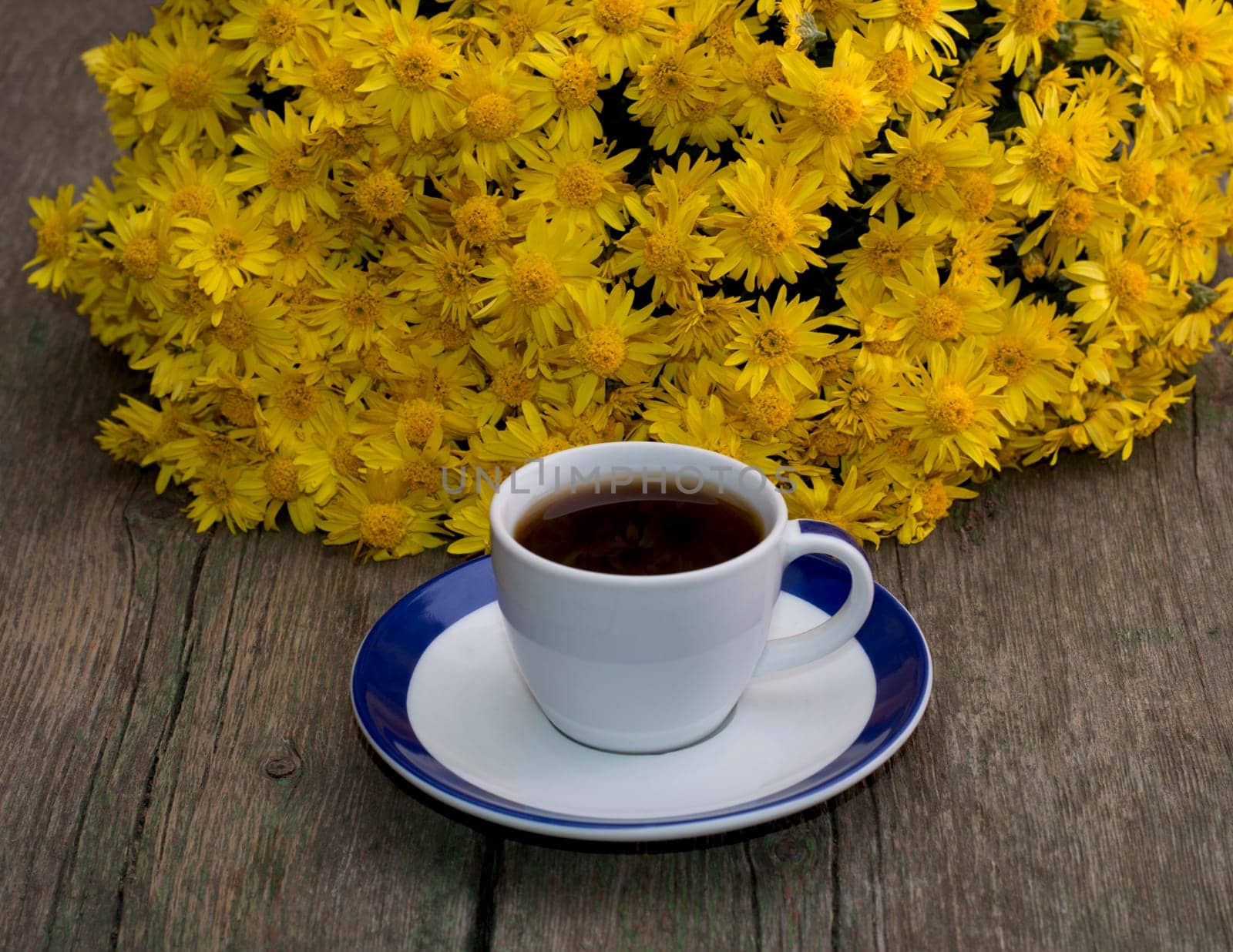 cup of coffee and beautiful bouquet of flowers, on a wooden table, a subject flowers and drinks