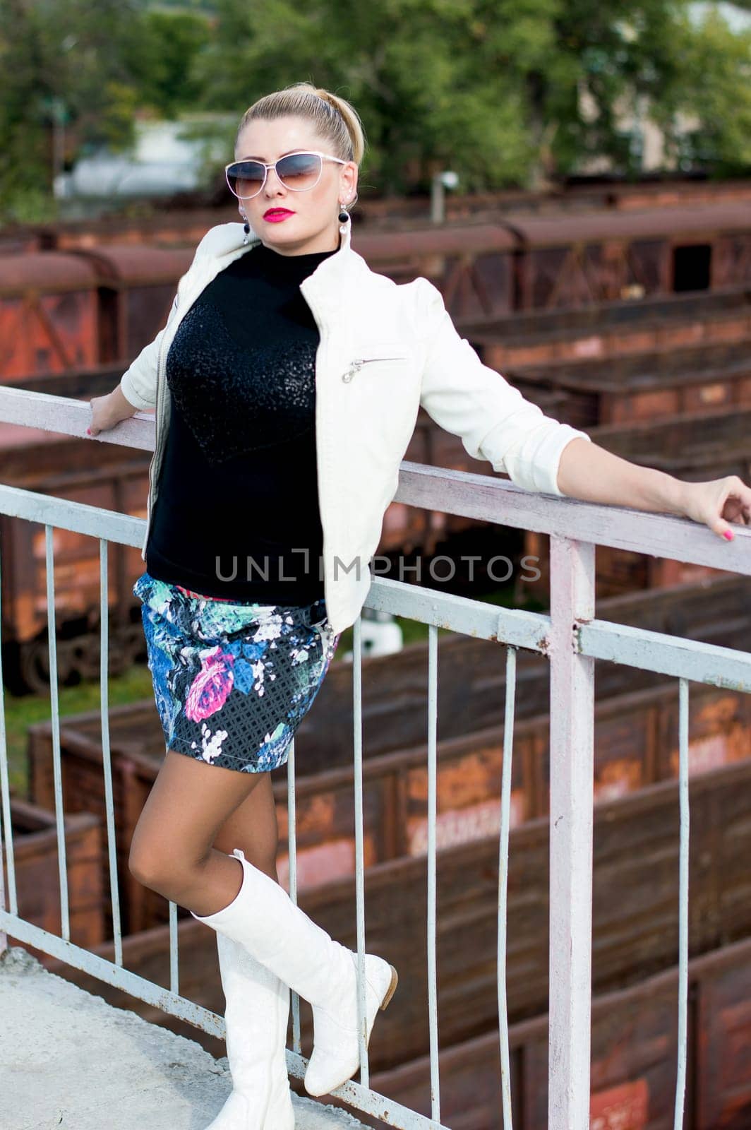the sexy woman in a miniskirt, on the bridge, against railway cars, railway roads, a subject beautiful women in different places