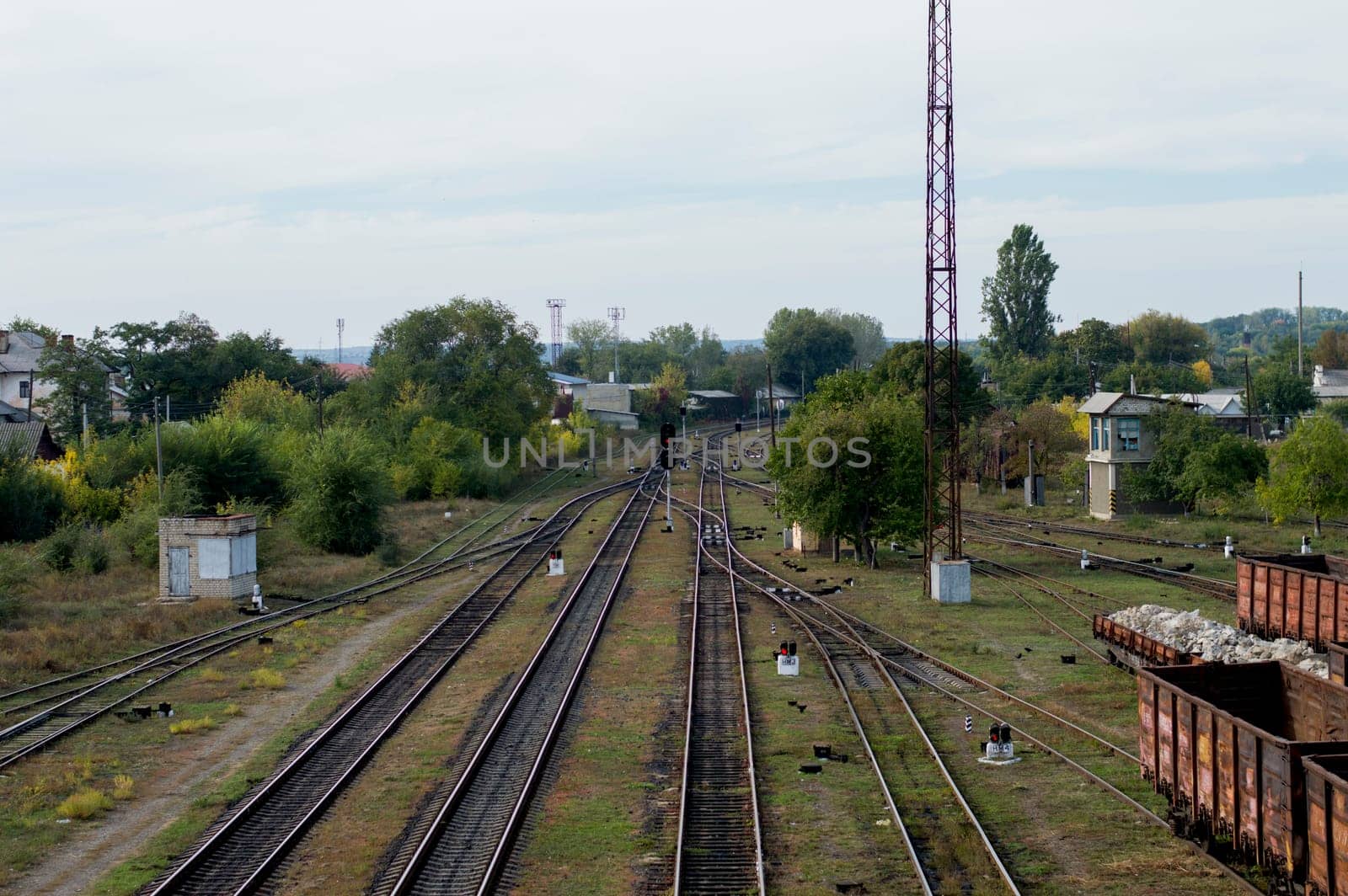 red light signal on a railway fork, railway tracks, a road subject
