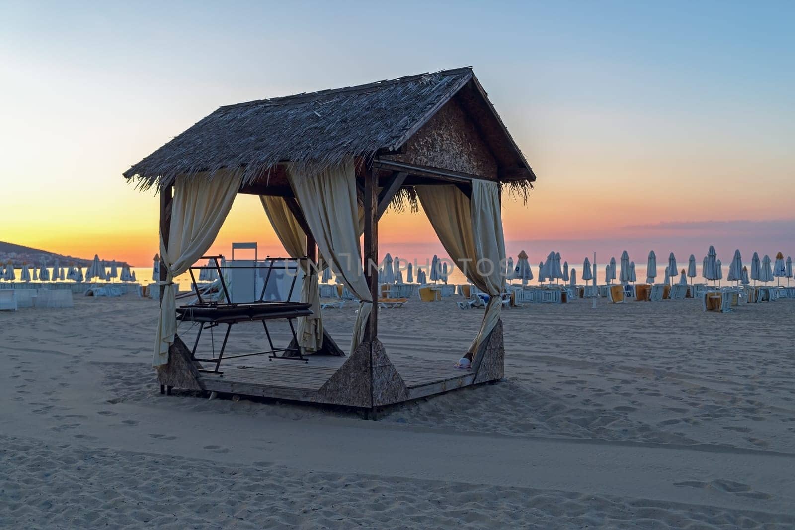Massage canopy on a sandy beach in the early morning. Shallow depth of field. Focus on foreground.