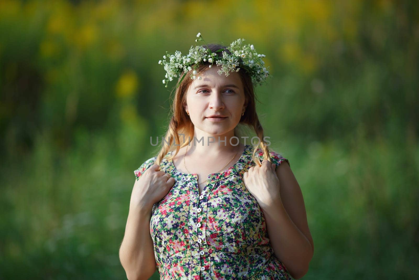 Woman with a wreath on his head holding his hair. Sunset light. Shallow depth of field. Focus on eyes.