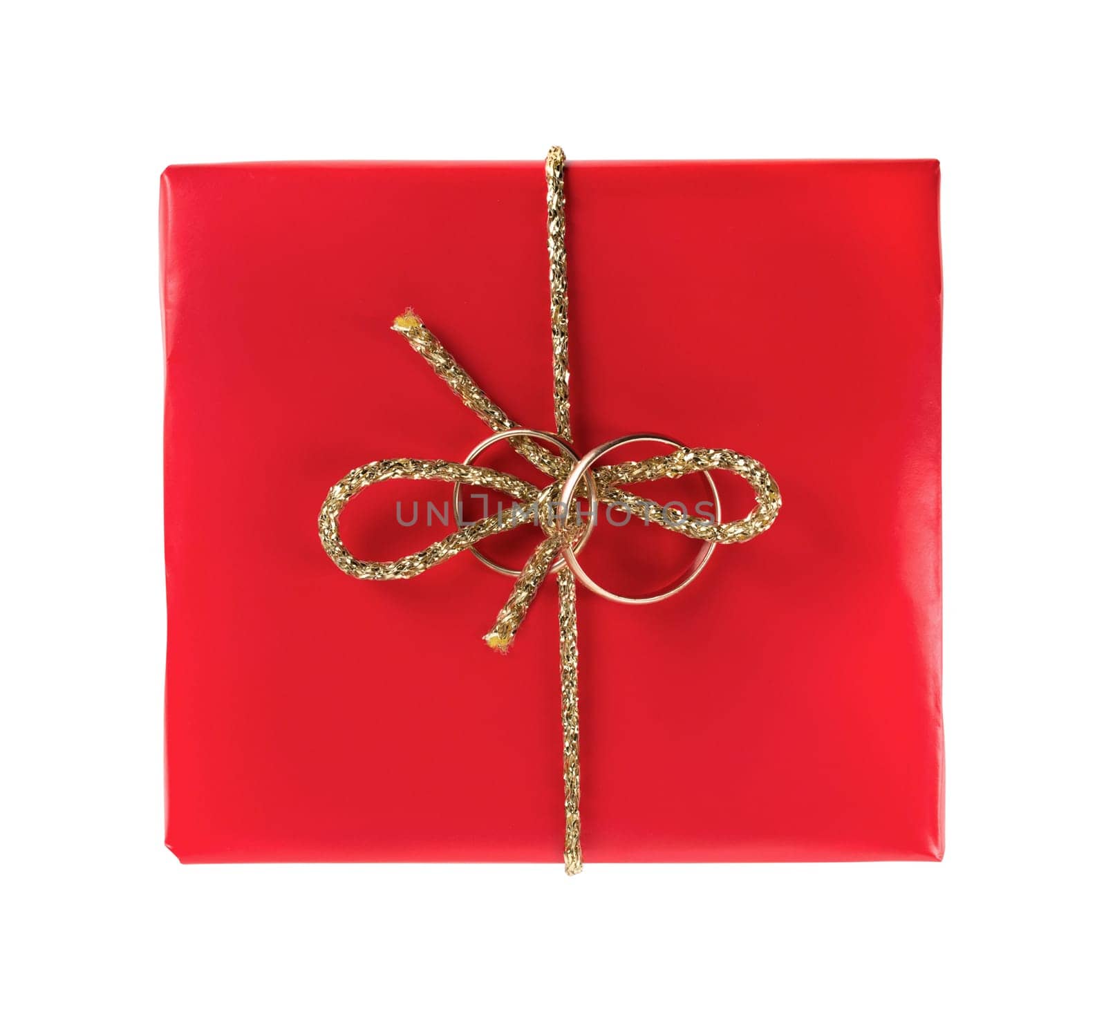 Red gift box with wedding rings on a white background. Isolated with clipping path. Top view.